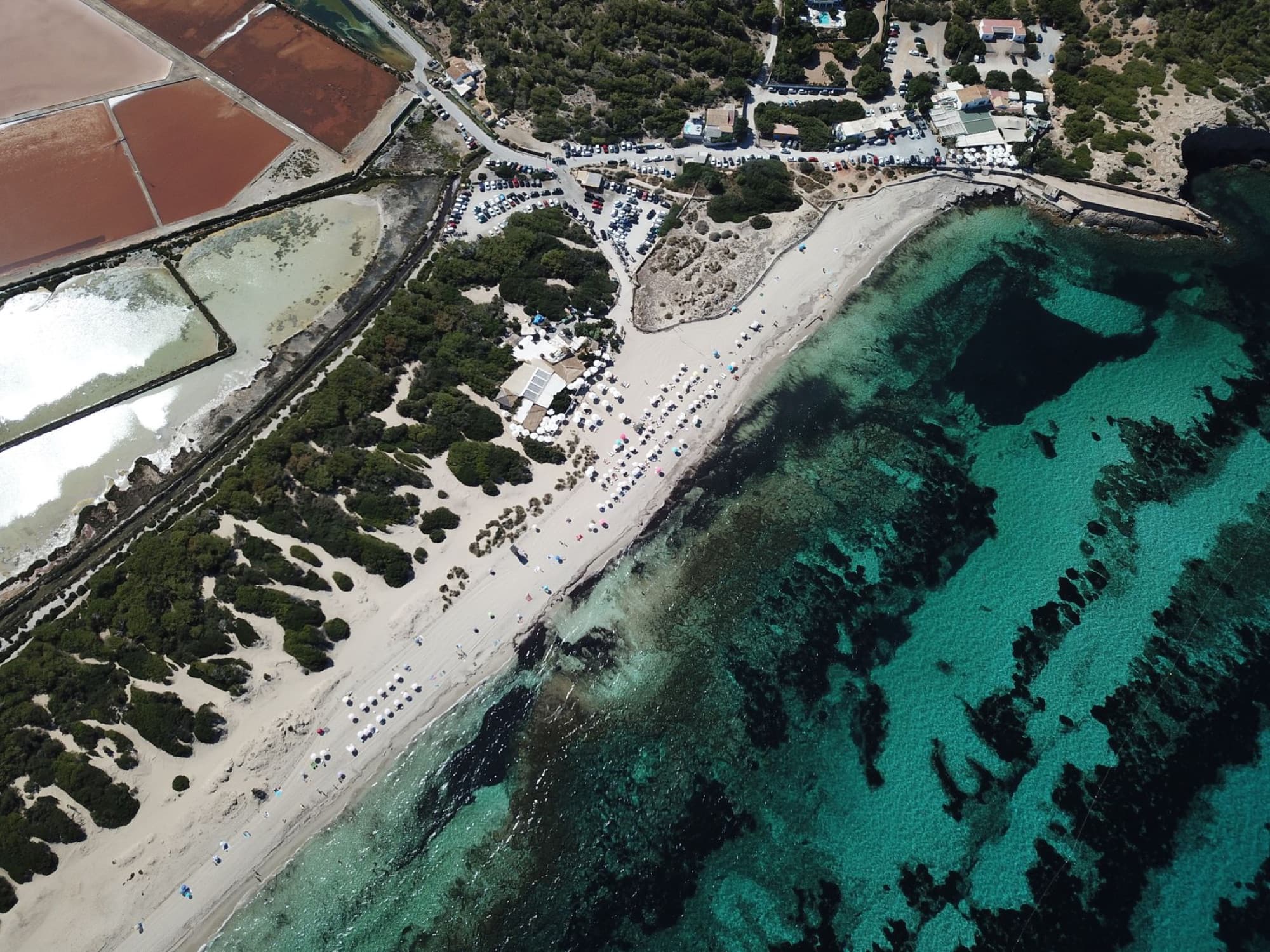Drone view of Salinas Beach, showing clear waters and salt flats in sunny Spain.