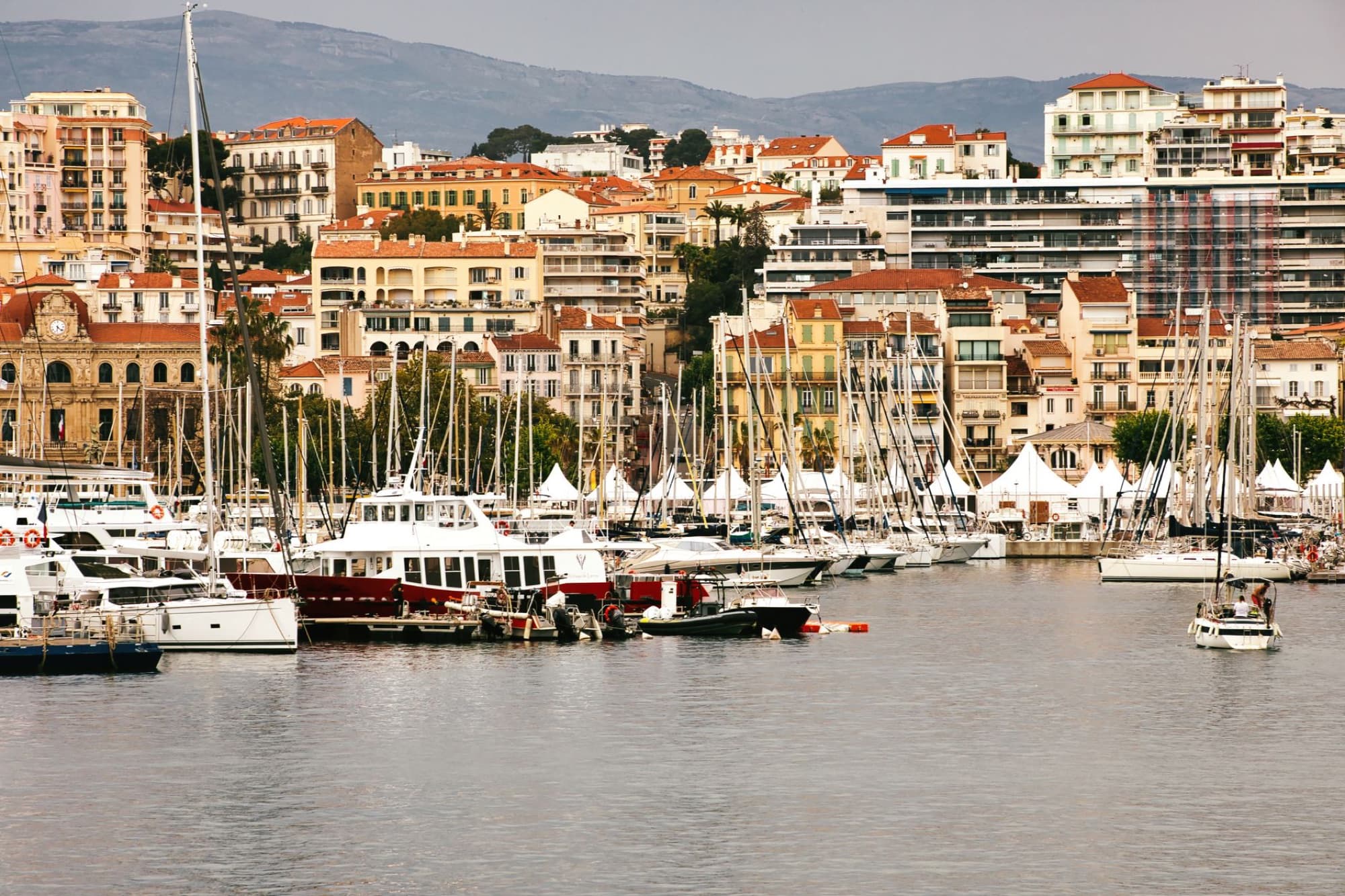 Beautiful view of Cannes harbor with moored yachts and historic buildings, capturing the essence of French Riviera charm.