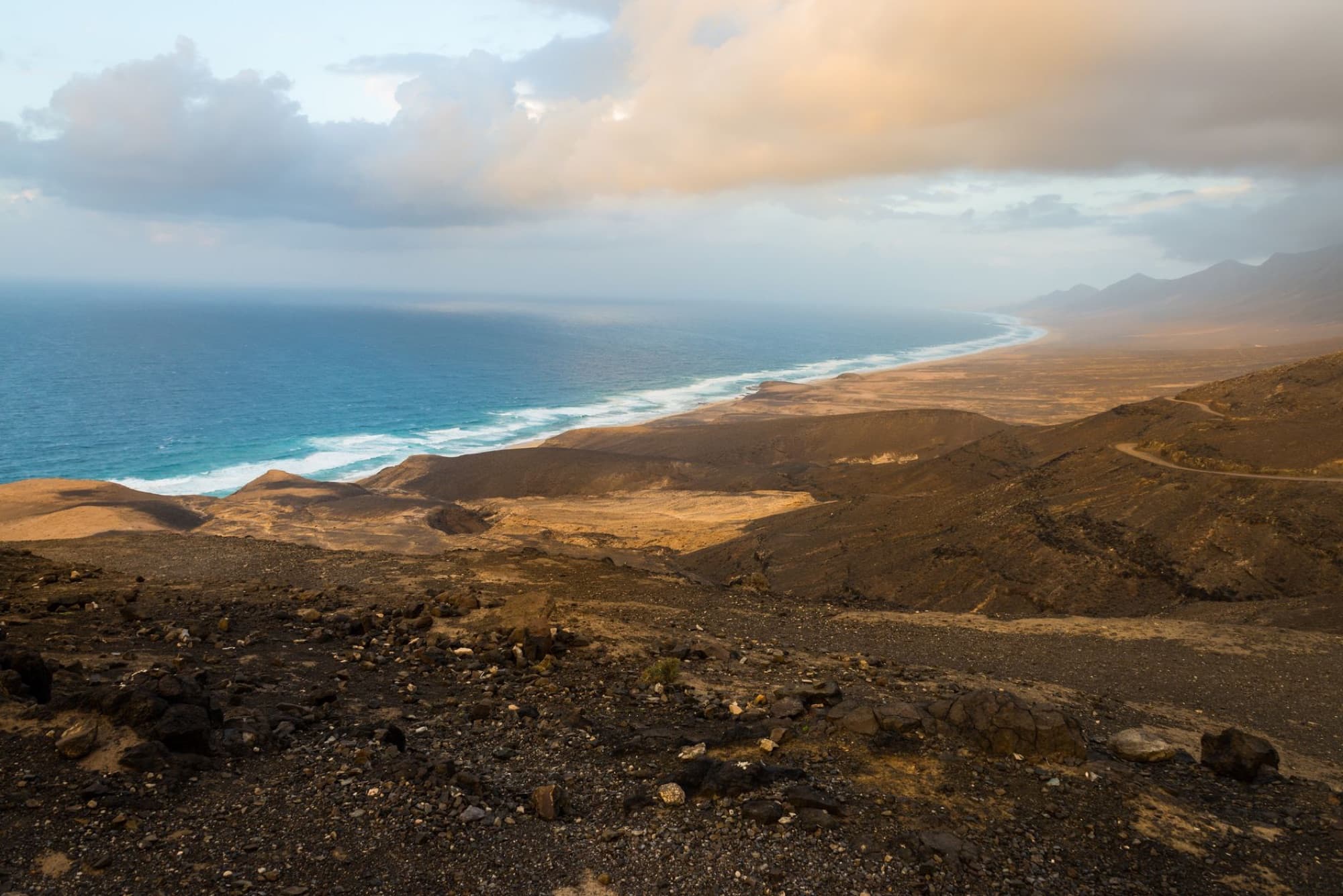 Stunning aerial shot of Fuerteventura's rugged coastline with dramatic skies and crashing waves.