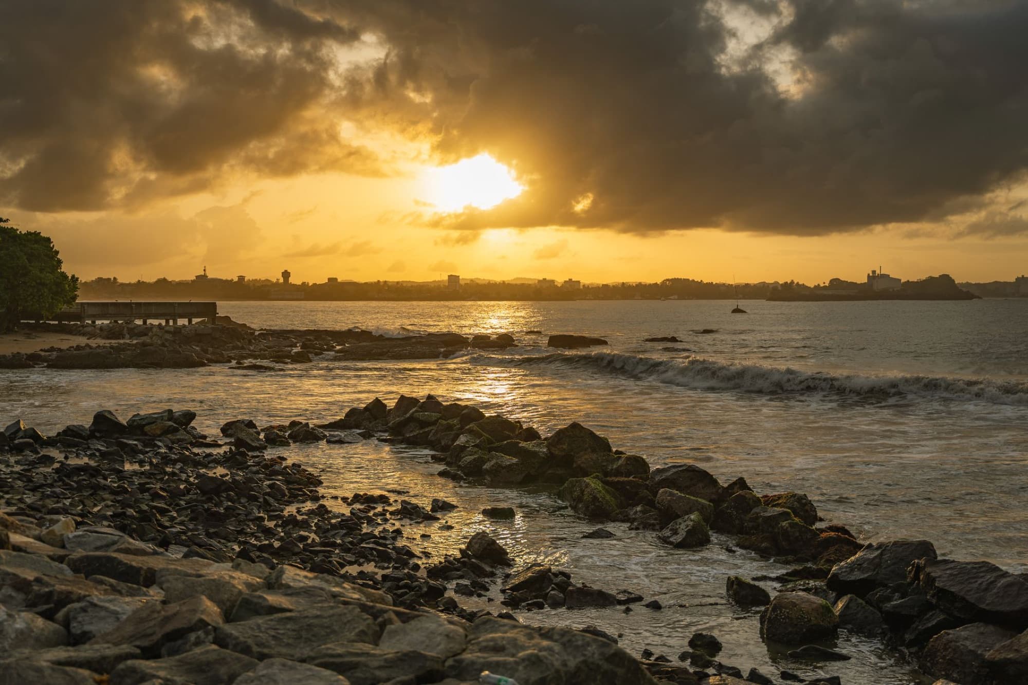 Dramatic sunset view over the rocky shoreline of Galle, Sri Lanka, with vibrant sky and ocean waves.