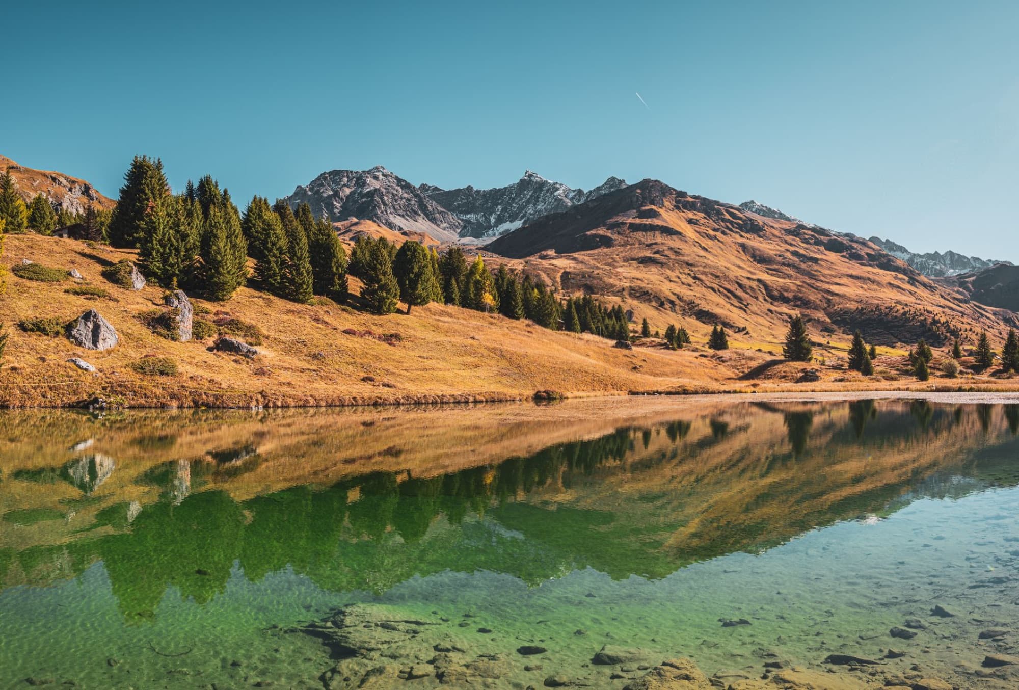 Breathtaking view of Alpine landscape with clear lake and mountains in Graubünden, Switzerland.