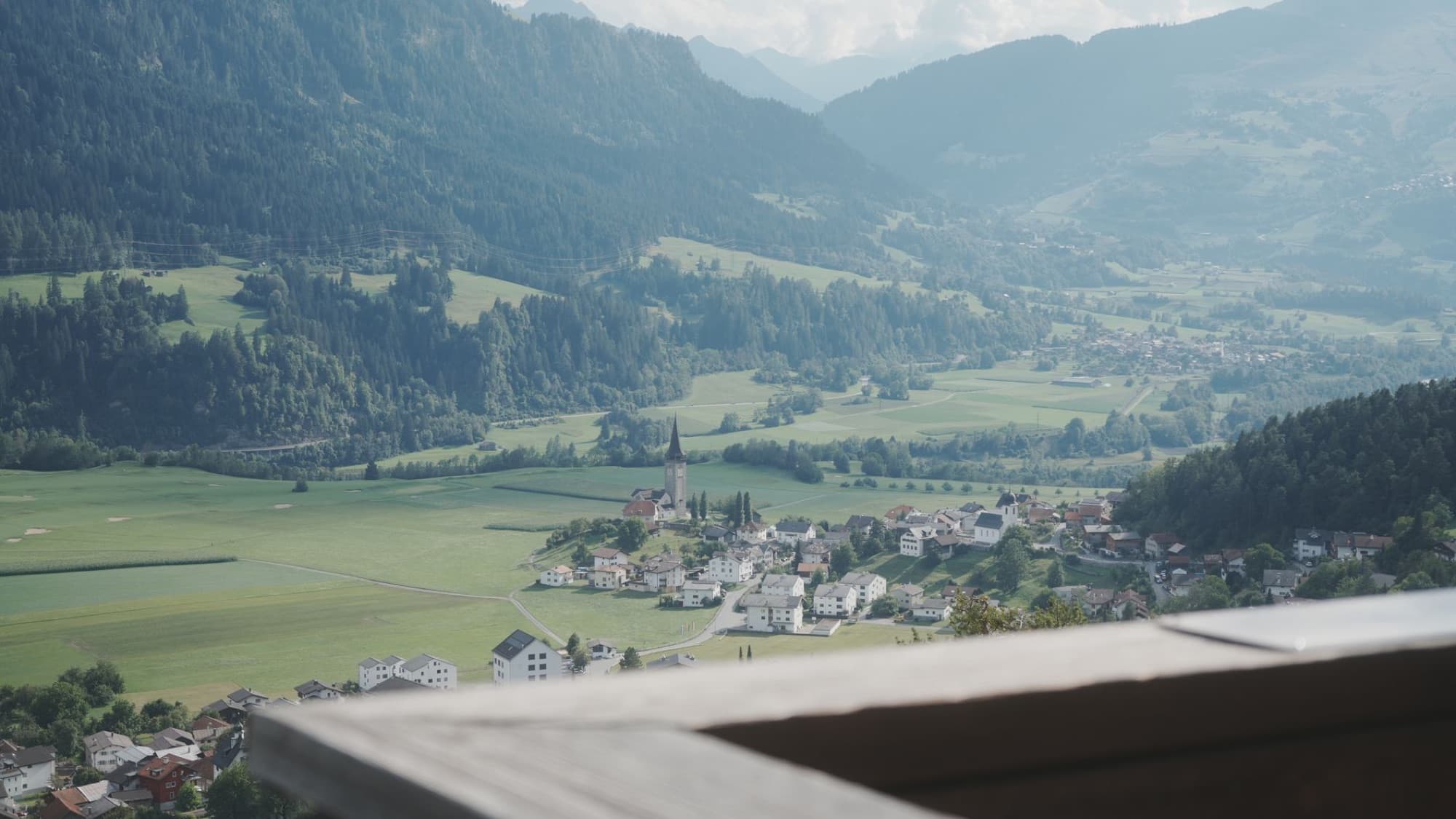 A picturesque aerial view of Sagogn village nestled in a lush Swiss valley.