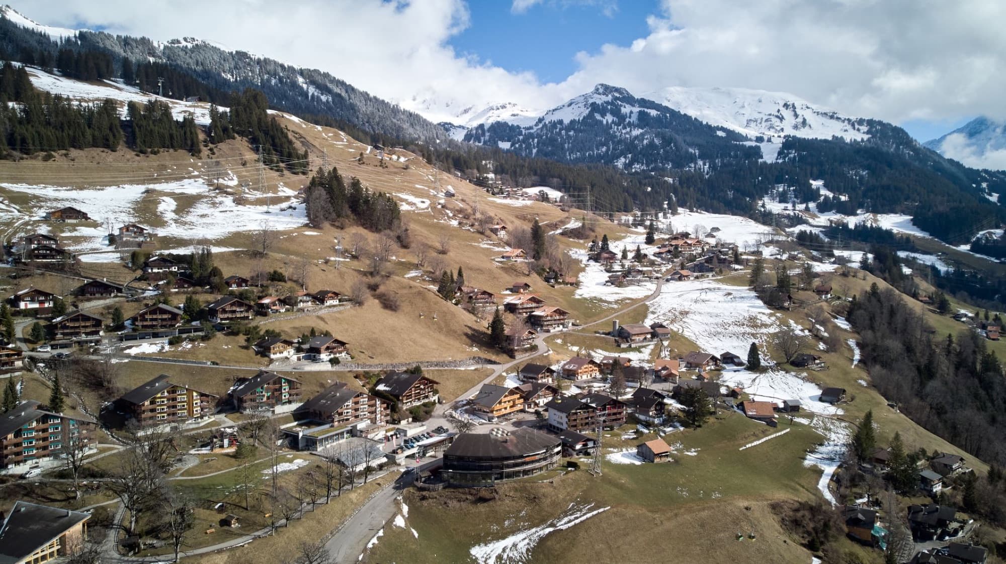 Scenic aerial panorama of Hasliberg village with snow-capped Alps.