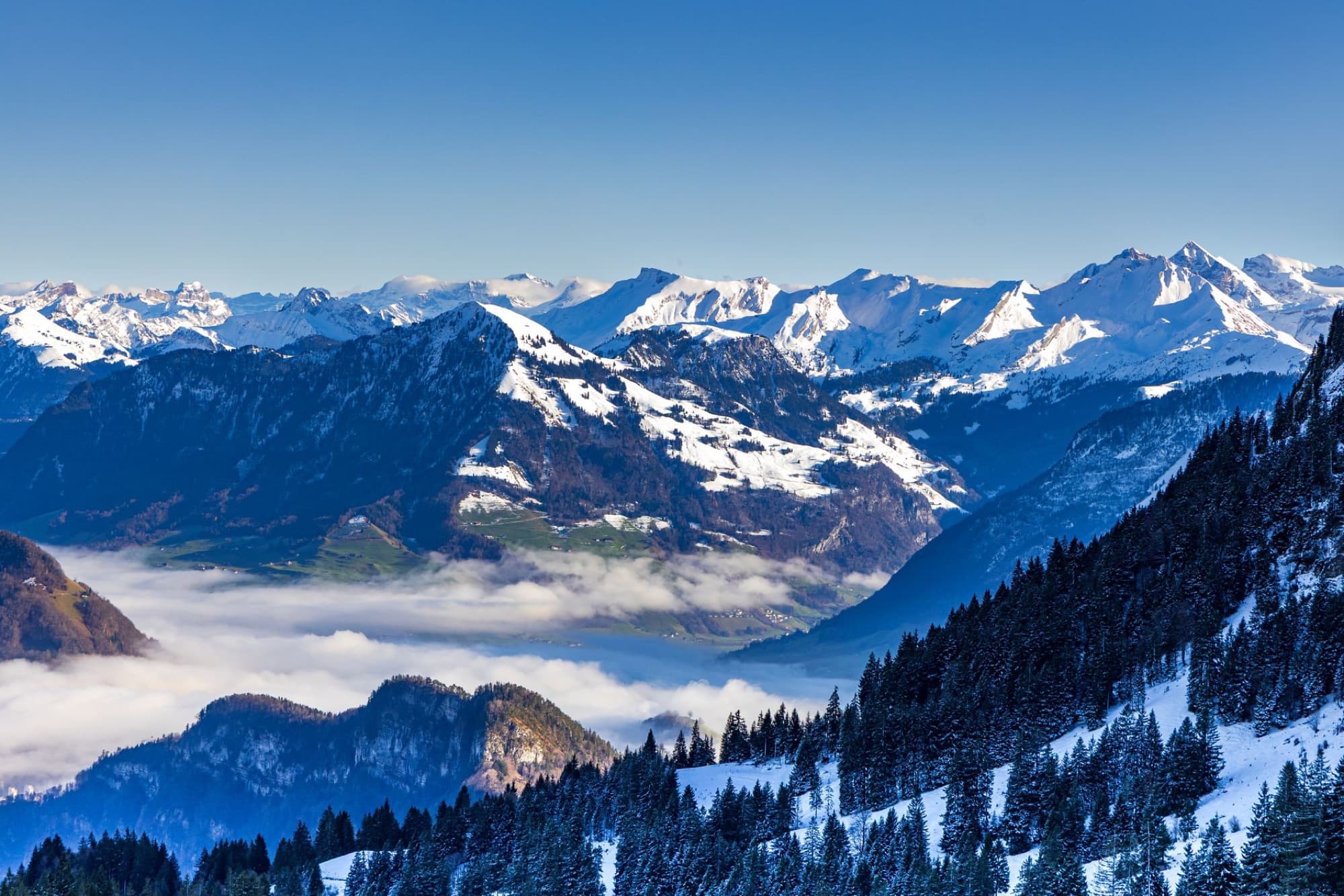 Spectacular aerial view of the Swiss Alps with snow-capped peaks and lush valleys, perfect for travel and nature enthusiasts.