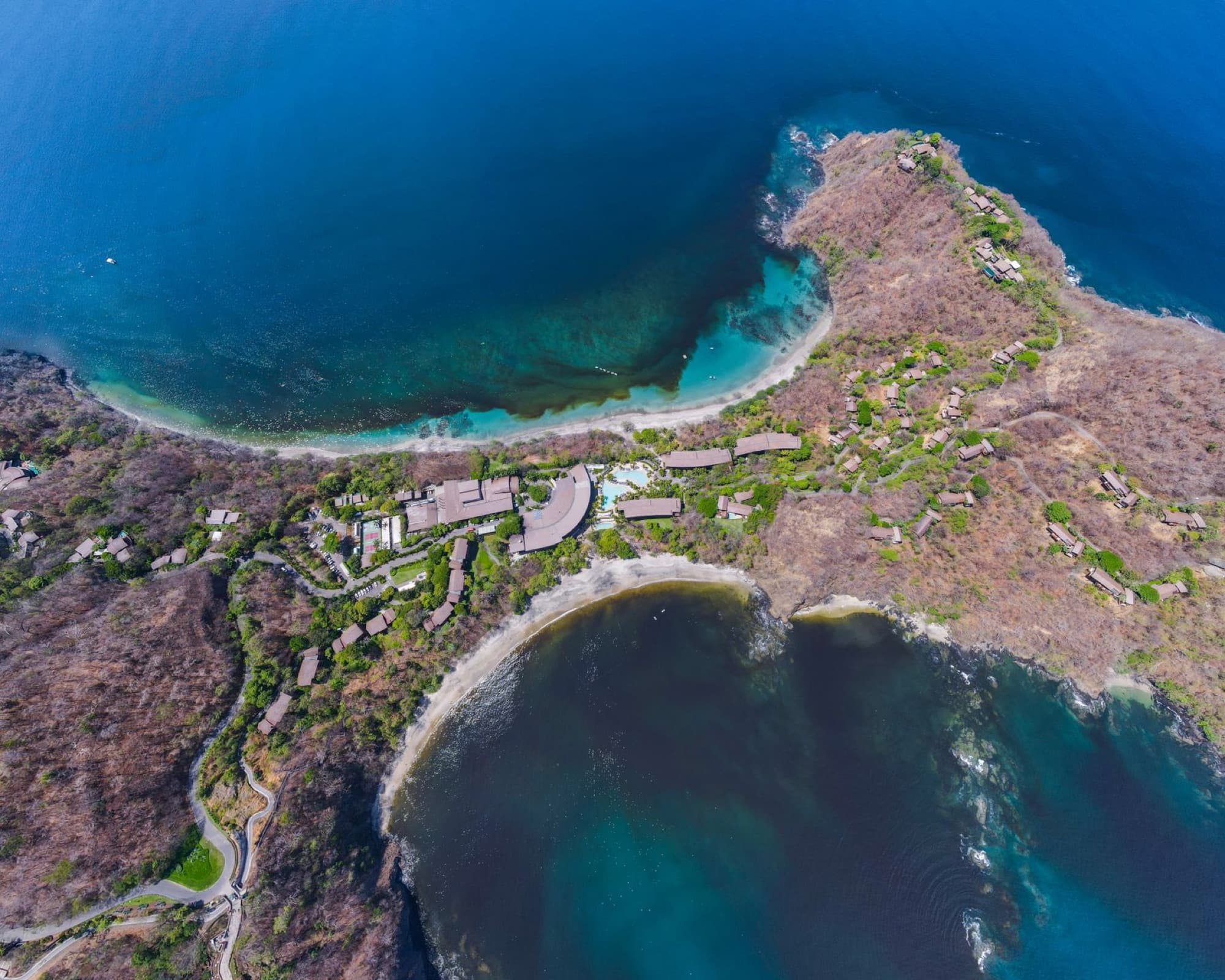 Scenic aerial view of Guanacaste Province coastline in Costa Rica, showcasing vibrant blue waters and rugged shorelines.