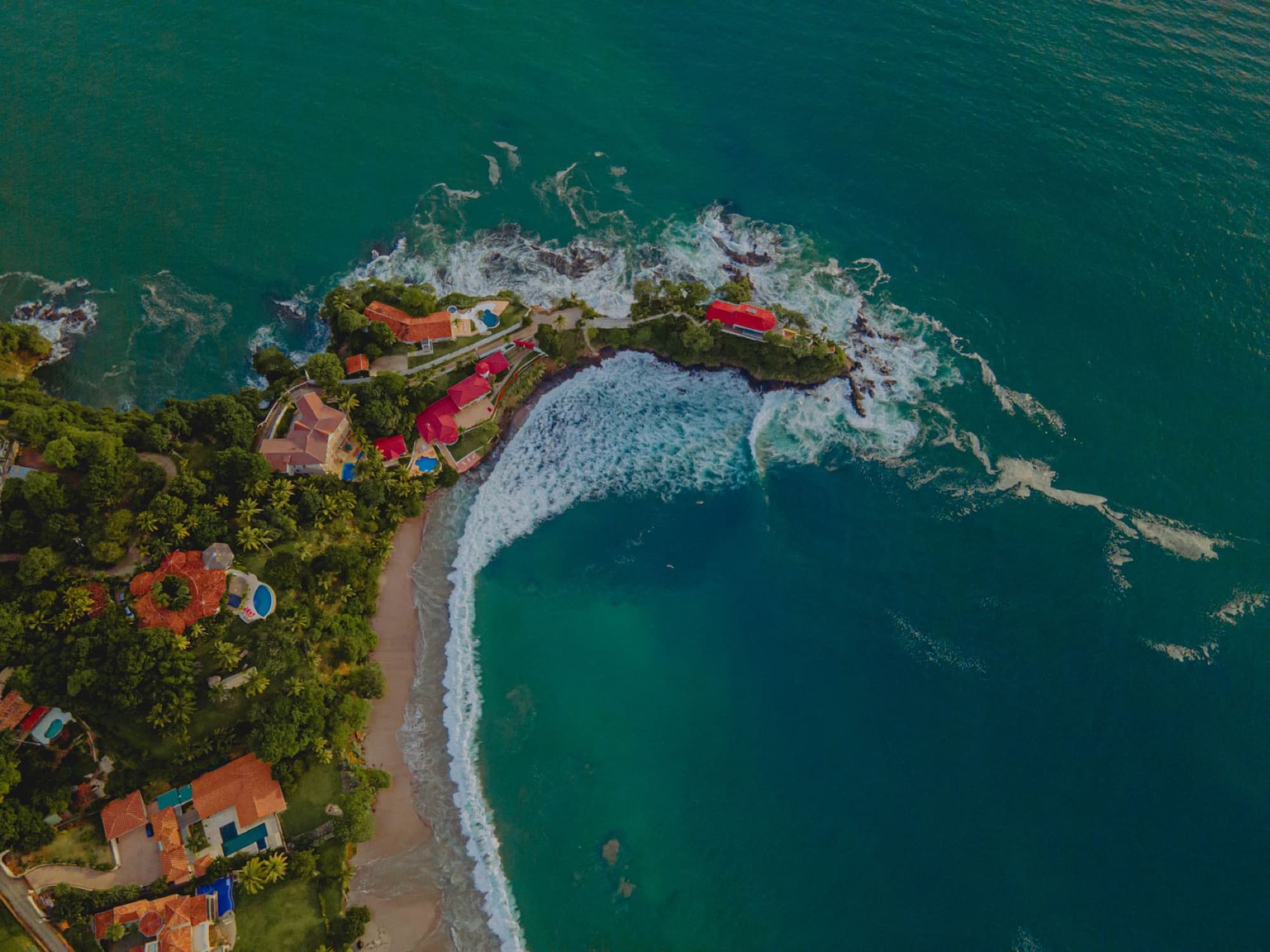 Stunning aerial shot of Playa Flamingo with lush greenery and turquoise waters in Guanacaste, Costa Rica.