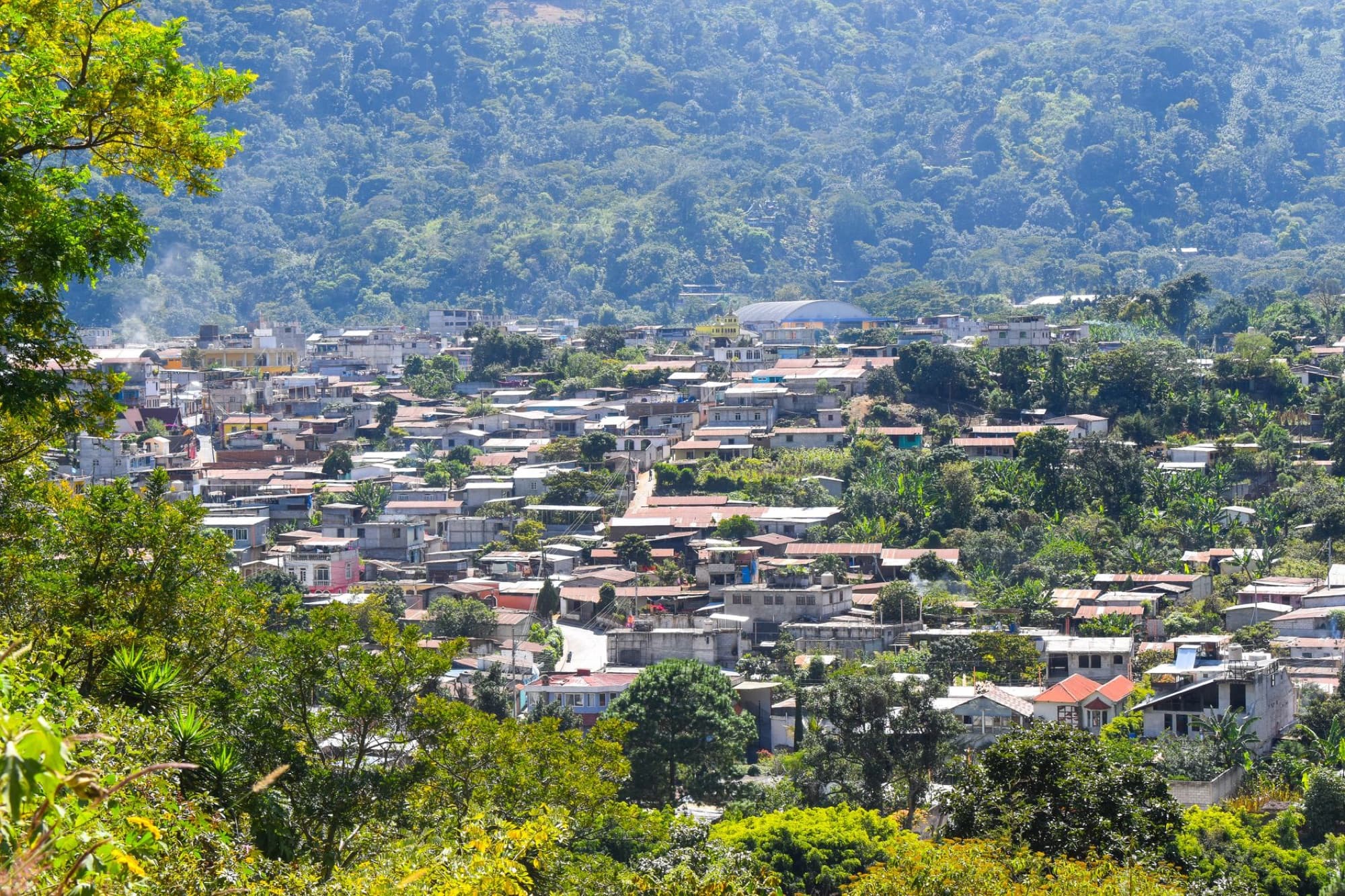 Captivating aerial view of a town surrounded by lush greenery in Ciudad de Guatemala, capturing the essence of local architecture.
