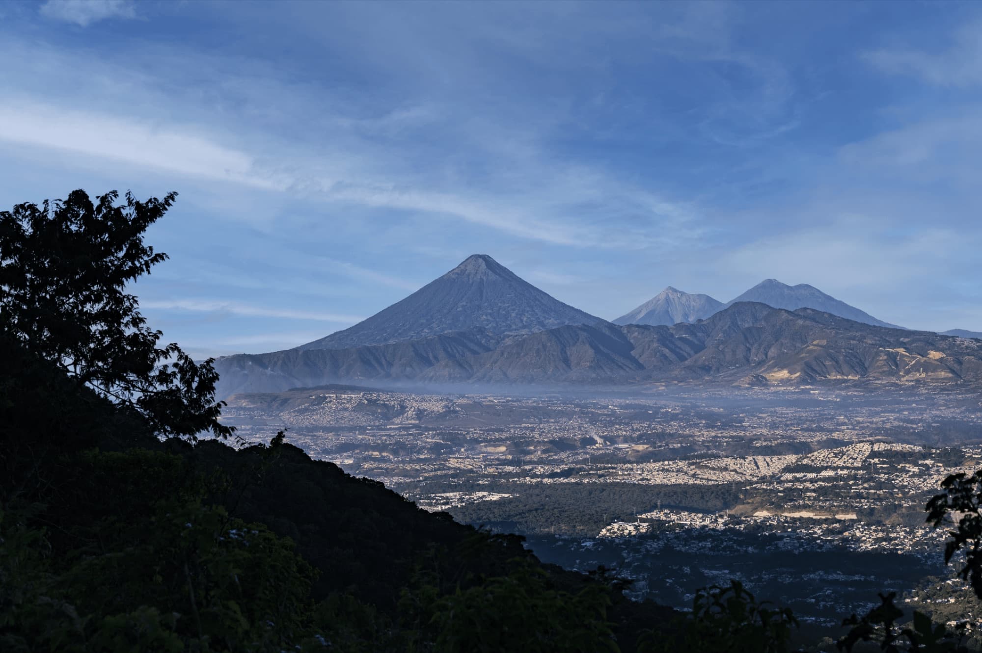 Stunning landscape of Guatemala's volcanic peaks under a vibrant blue sky, capturing lush nature.