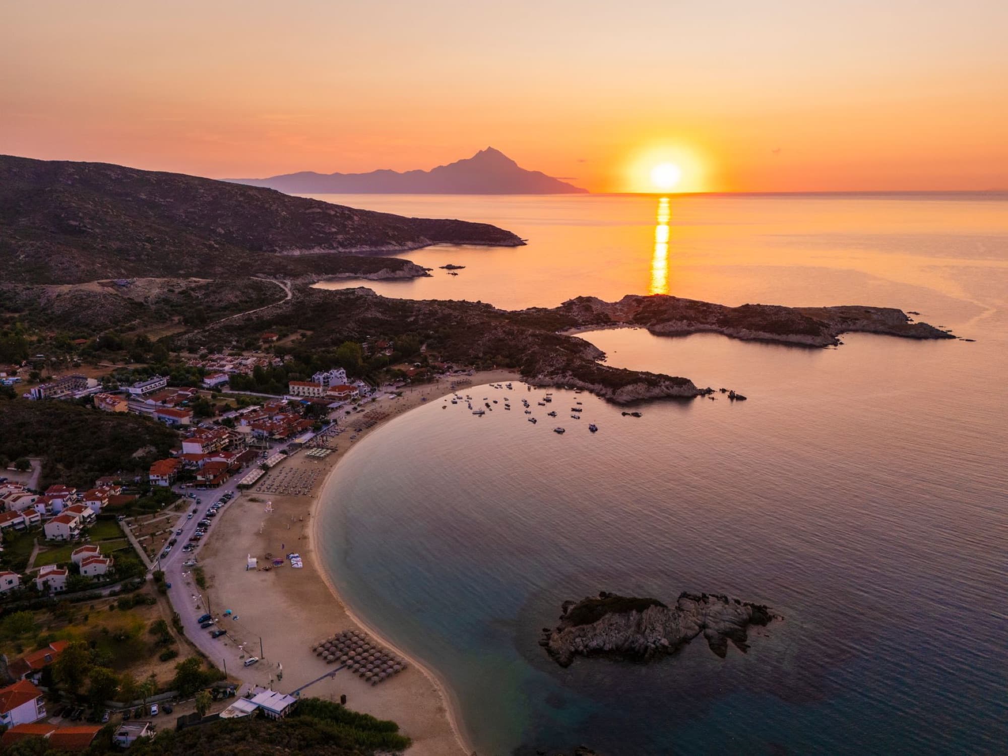 Scenic aerial view of Kalamitsi Beach, Greece at sunrise with a stunning coastline and calm sea.