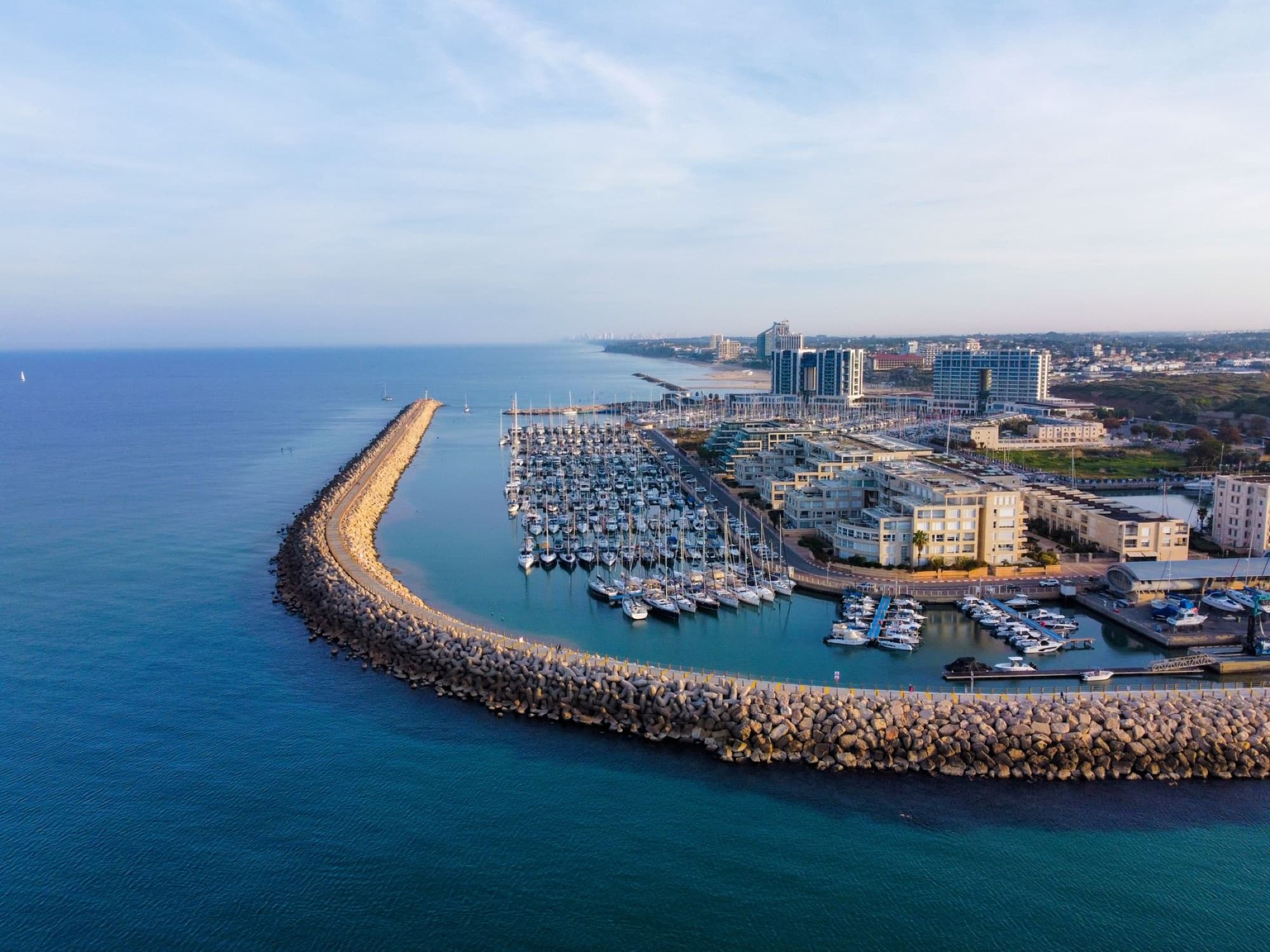 Drone view of Herzliya Marina with yachts and coastline in Israel's Mediterranean Sea.