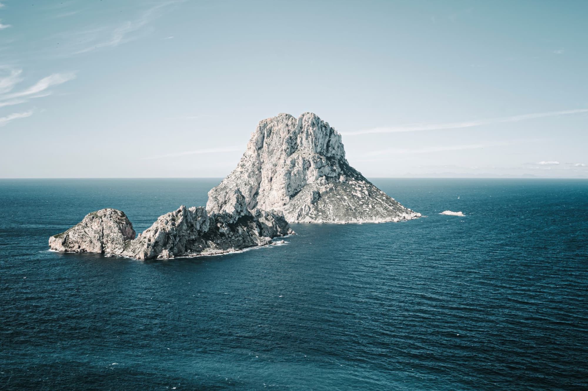 Breathtaking aerial view of Es Vedrà, off the coast of Ibiza, surrounded by the Mediterranean Sea.