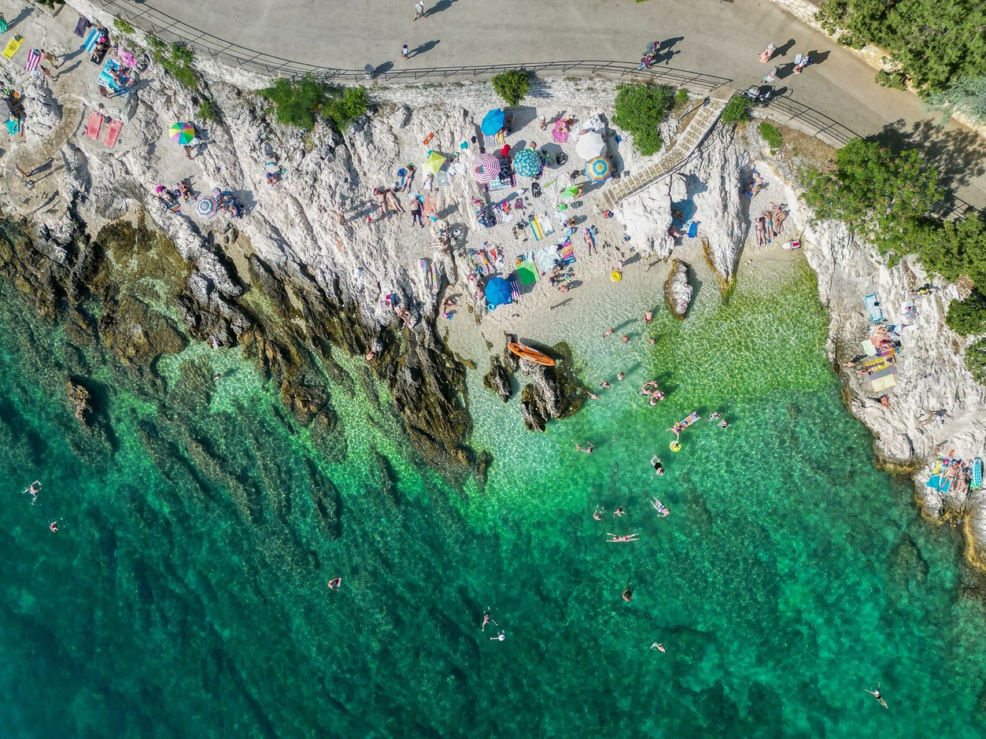 A stunning aerial view of Rabac beach showcasing the rocky coastline and clear turquoise waters.