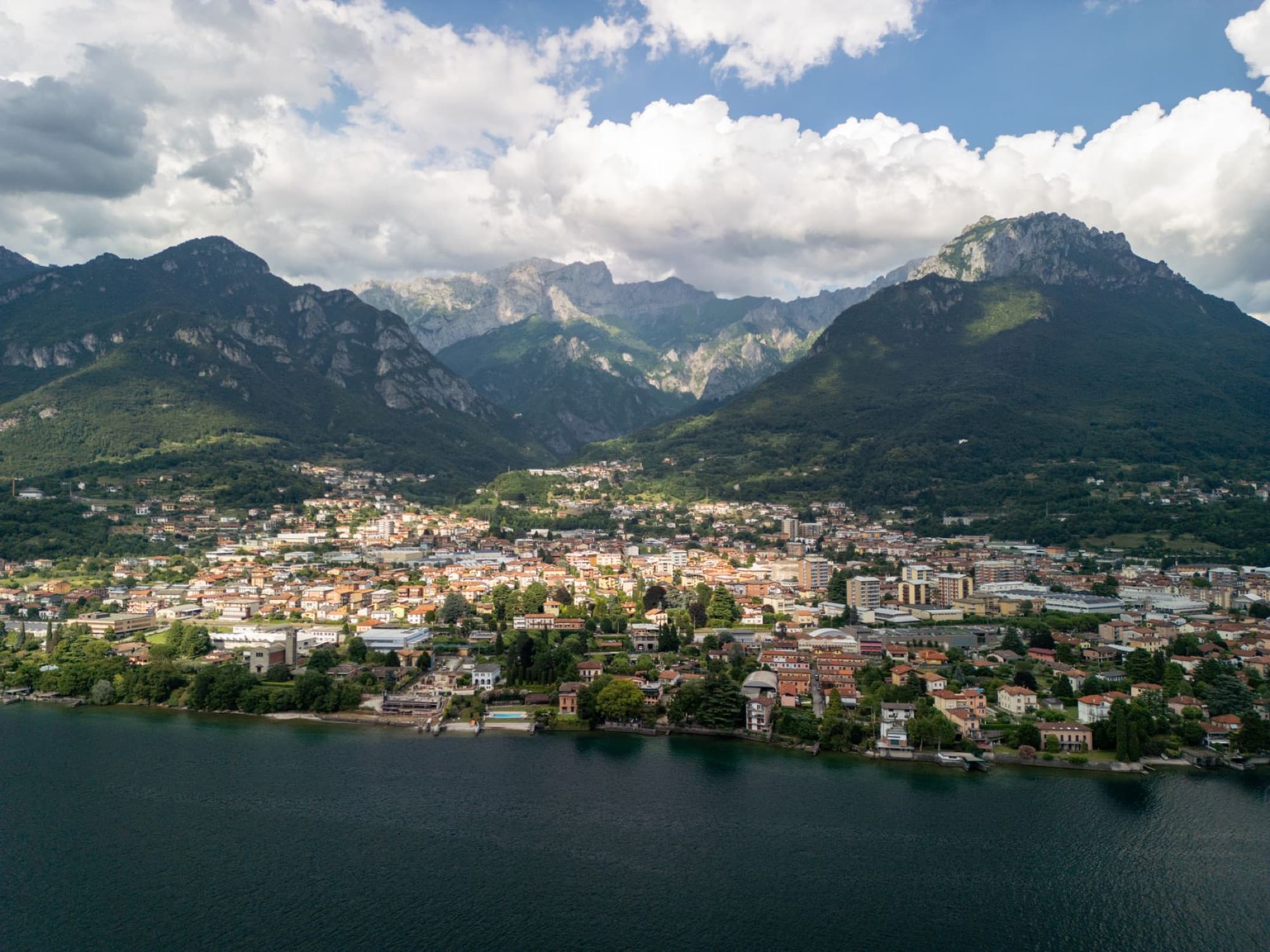 A stunning aerial shot showcasing the breathtaking landscape of an Italian lakeside town surrounded by mountains.