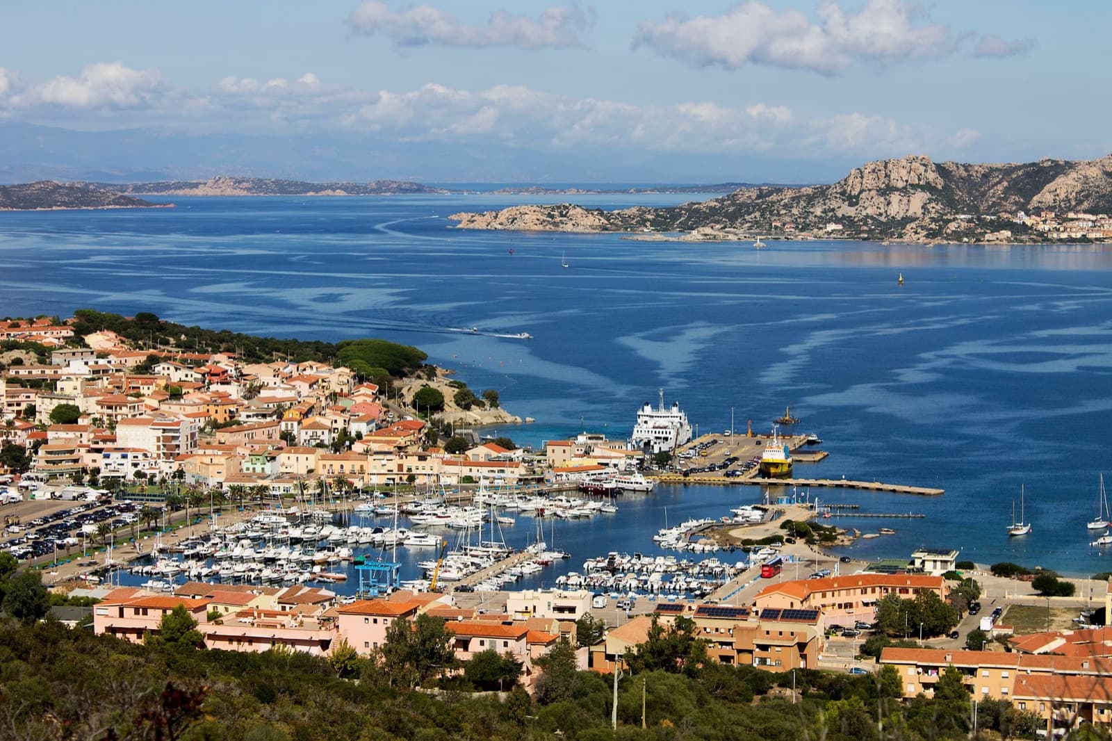 Scenic aerial shot of Palau harbor and town in Sardinia, showcasing vibrant coastal life.