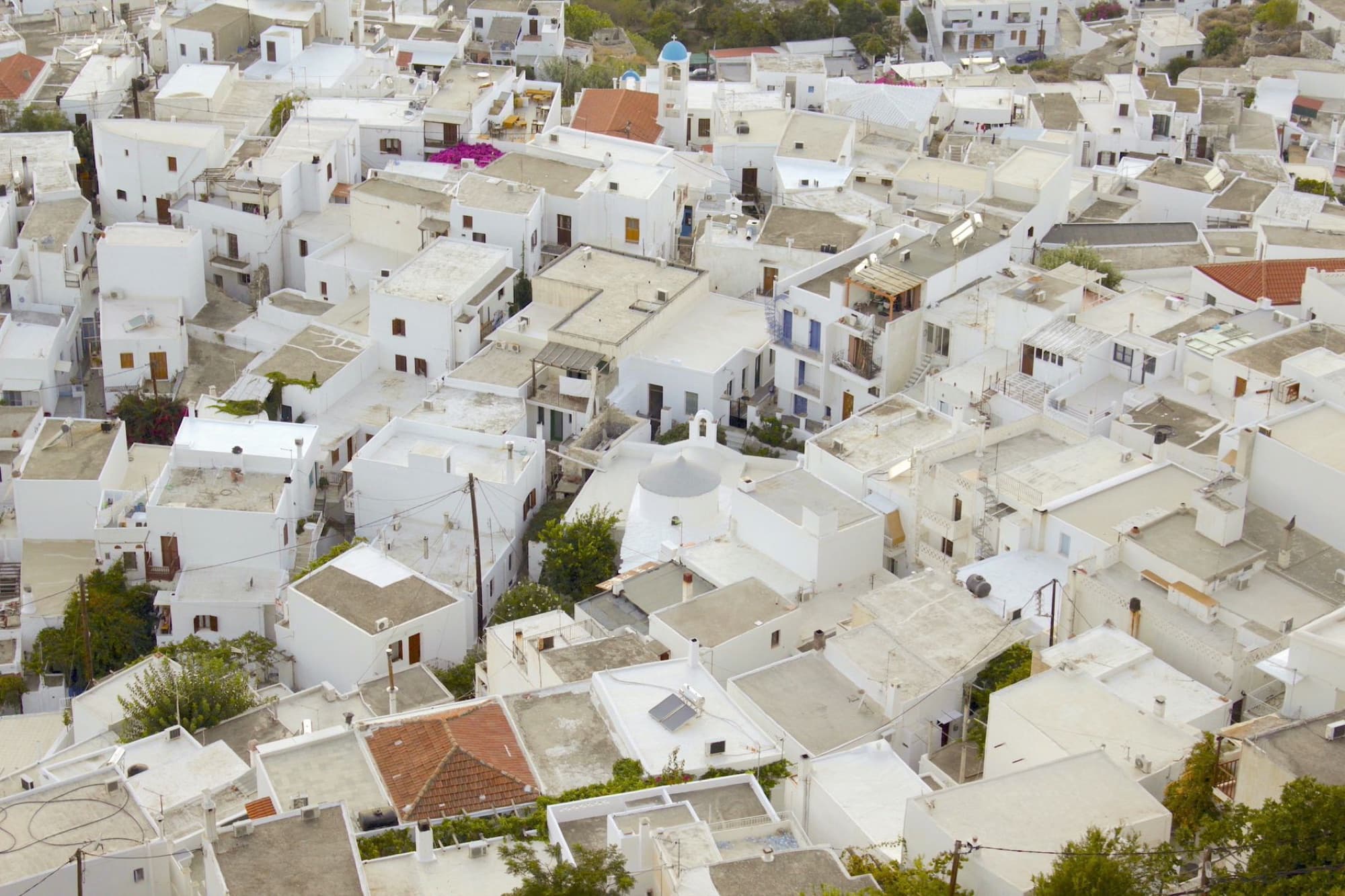 Stunning aerial photograph showcasing the dense cluster of whitewashed houses in a traditional Greek town.
