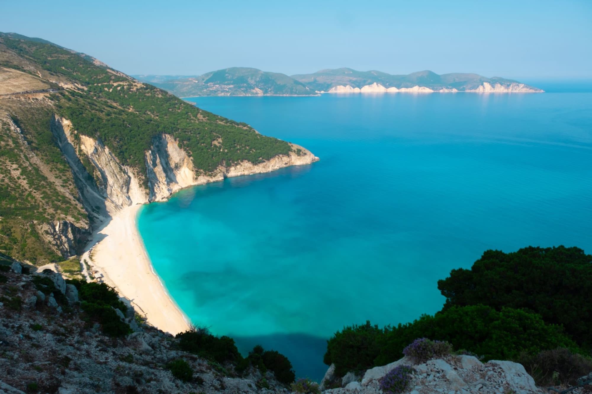 Stunning view of a turquoise bay with cliffs and beach on a Greek island.