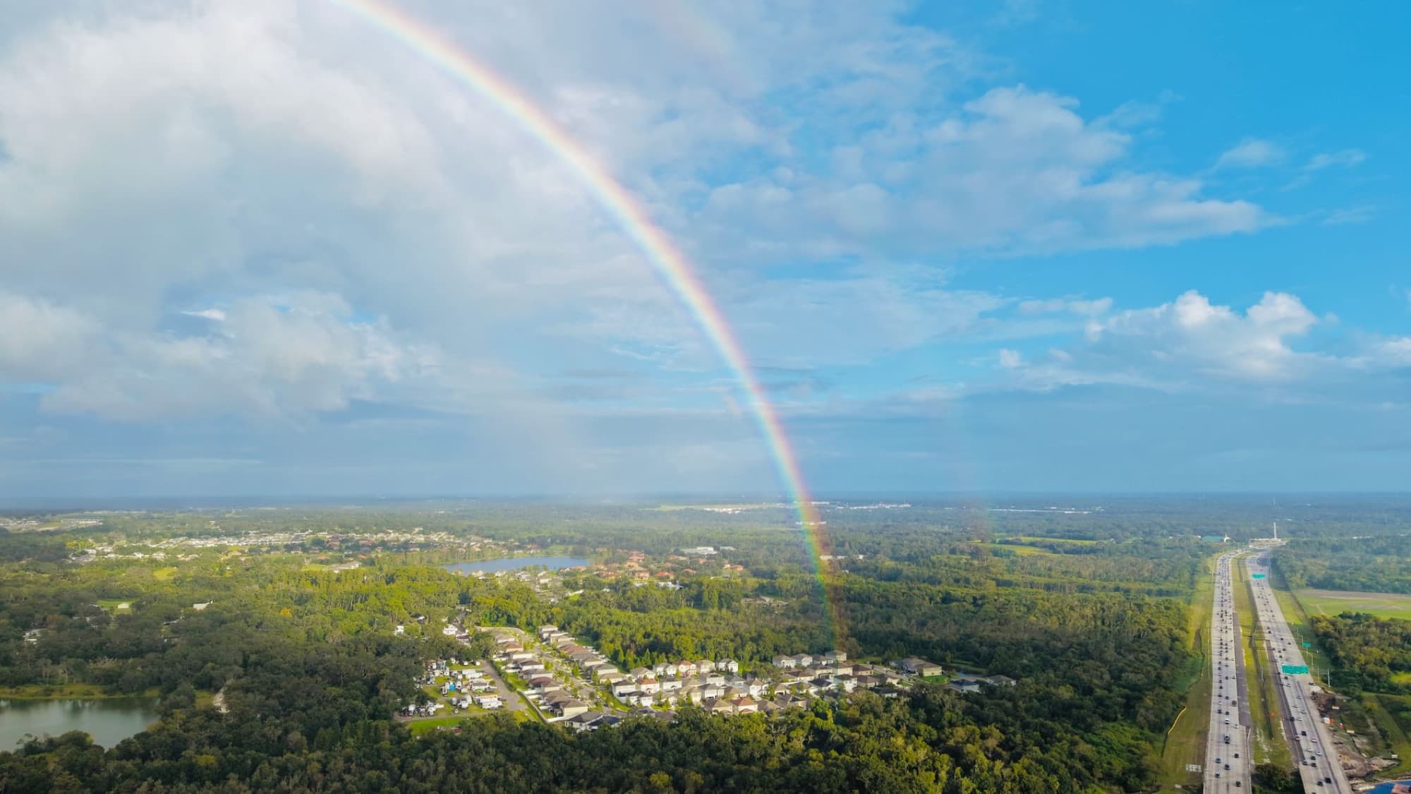Stunning aerial view of a Florida landscape featuring a vibrant rainbow over lush greenery.