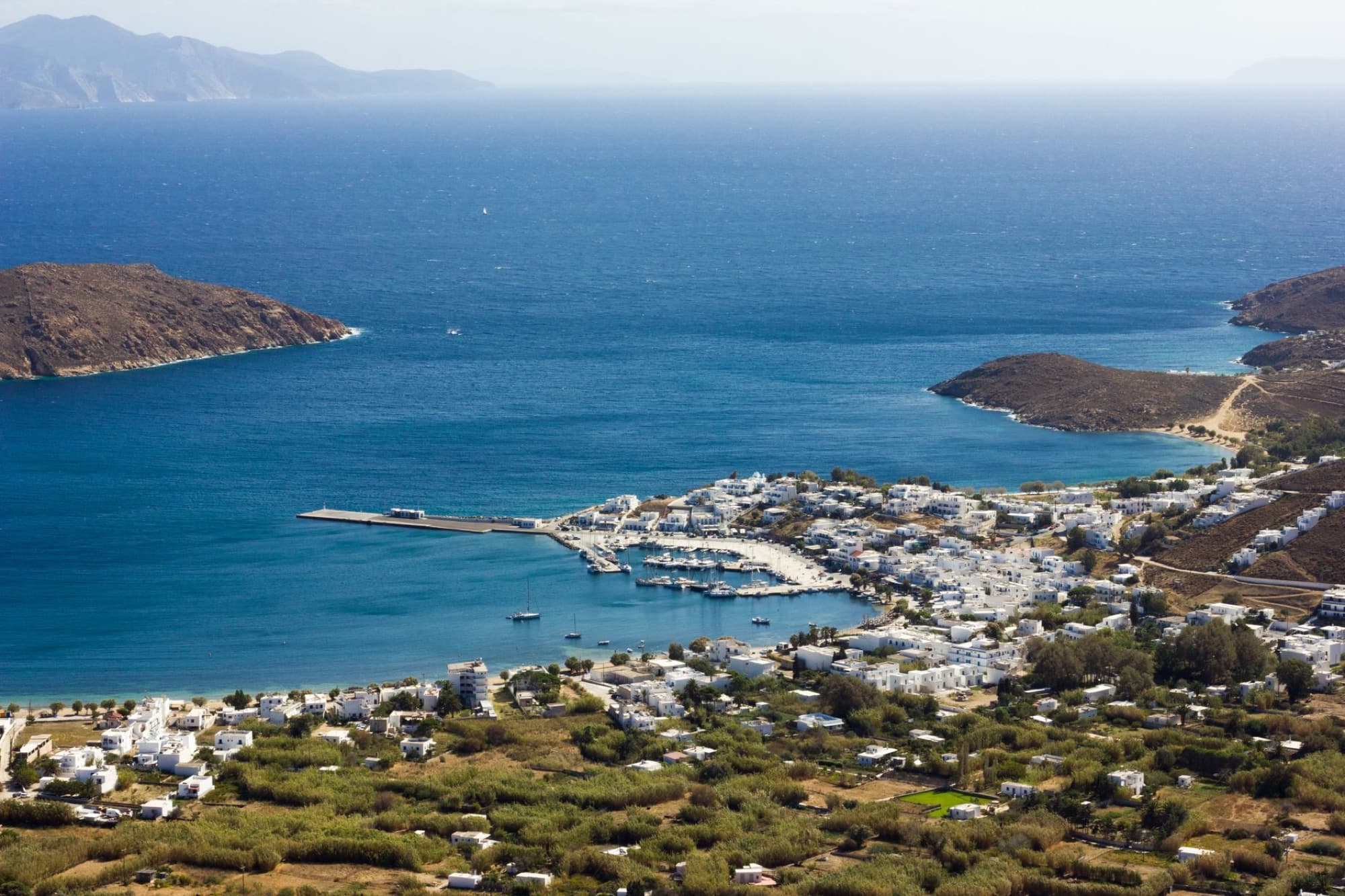Aerial view of a charming coastal town in Greece with azure waters and scenic landscape.