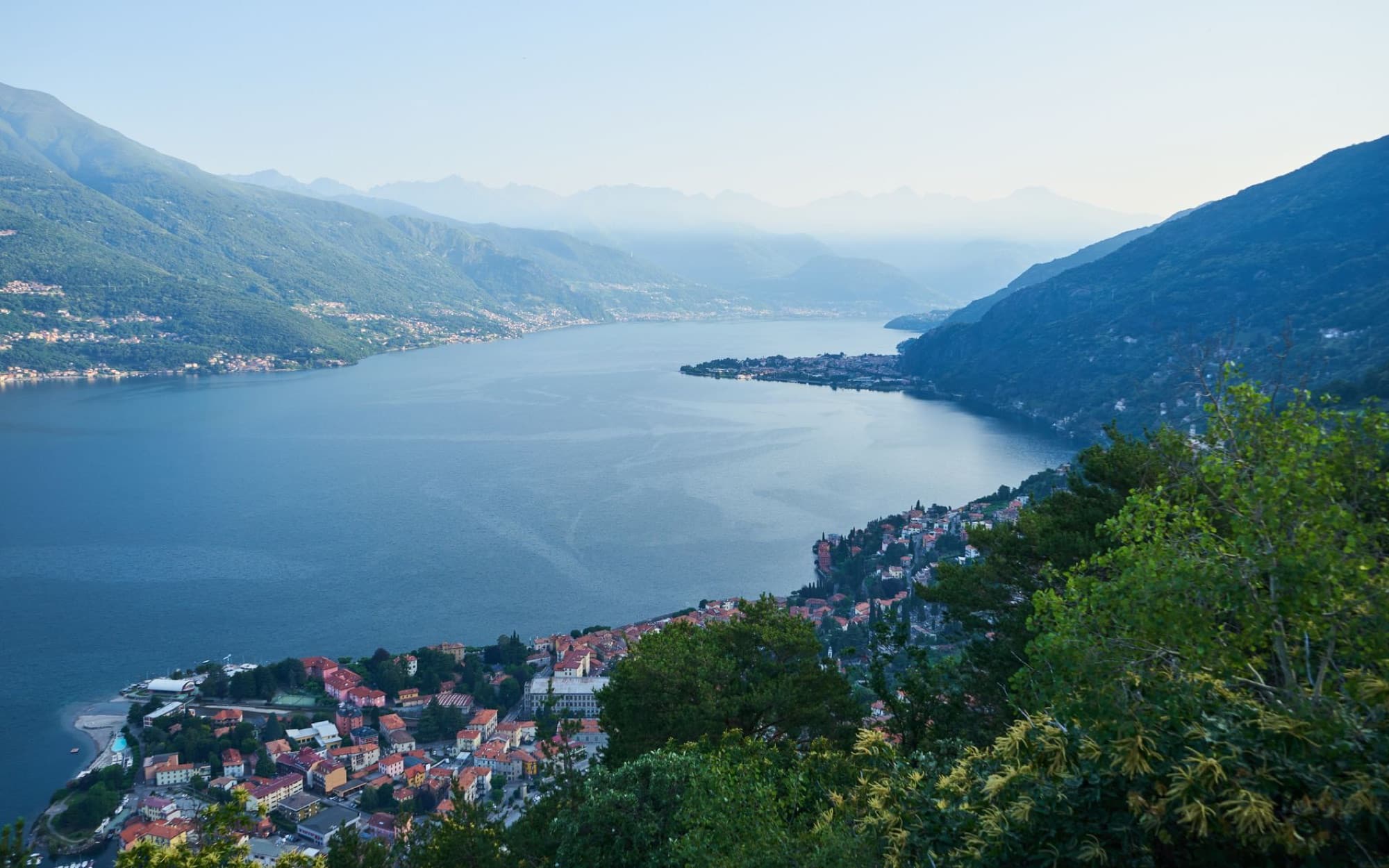 Panoramic view of Lake Como and Bellano town nestled in Lombardy's lush landscape.