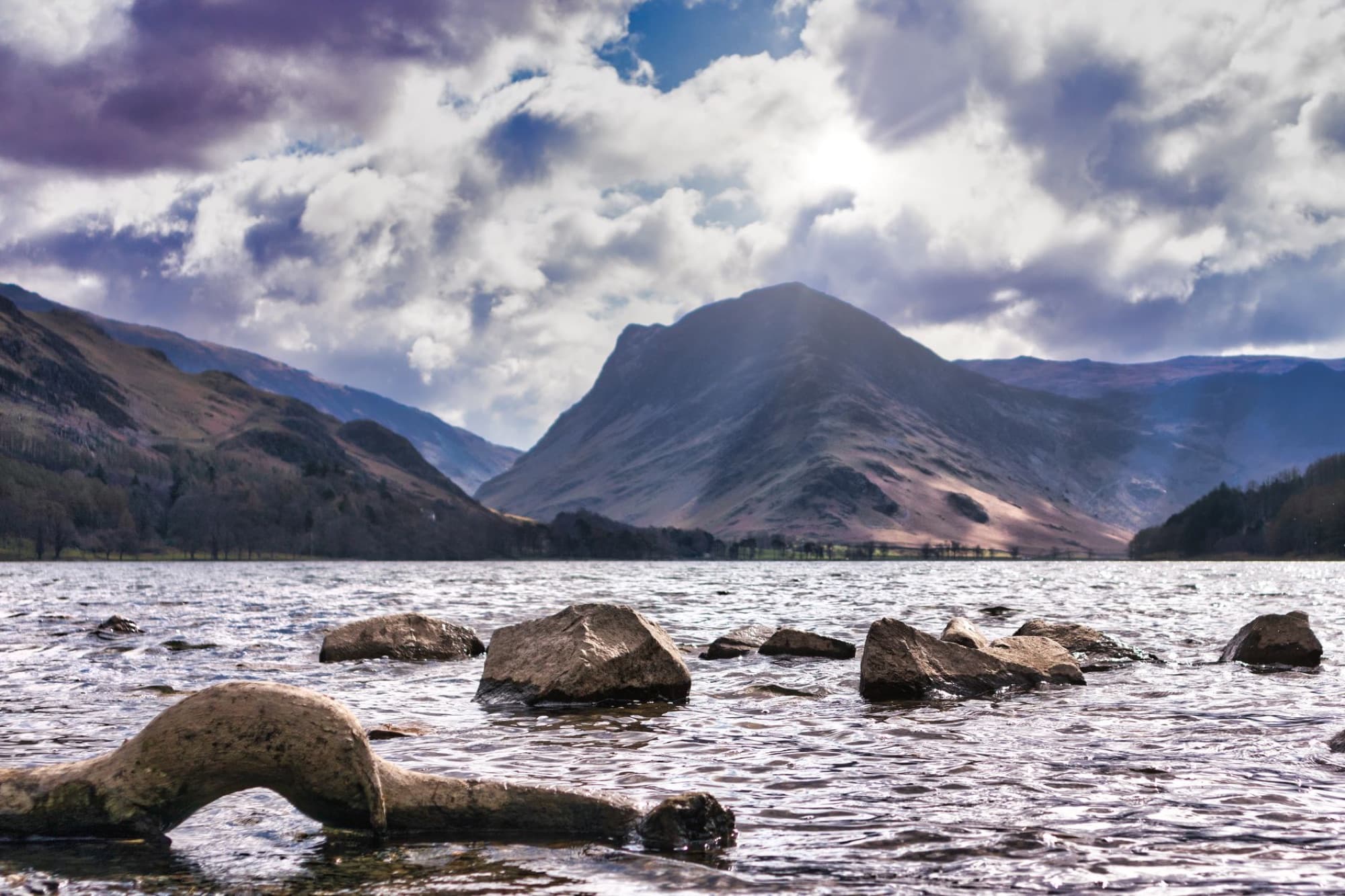 Capture of a serene lake and mountains under a cloudy sky in England's Lake District.