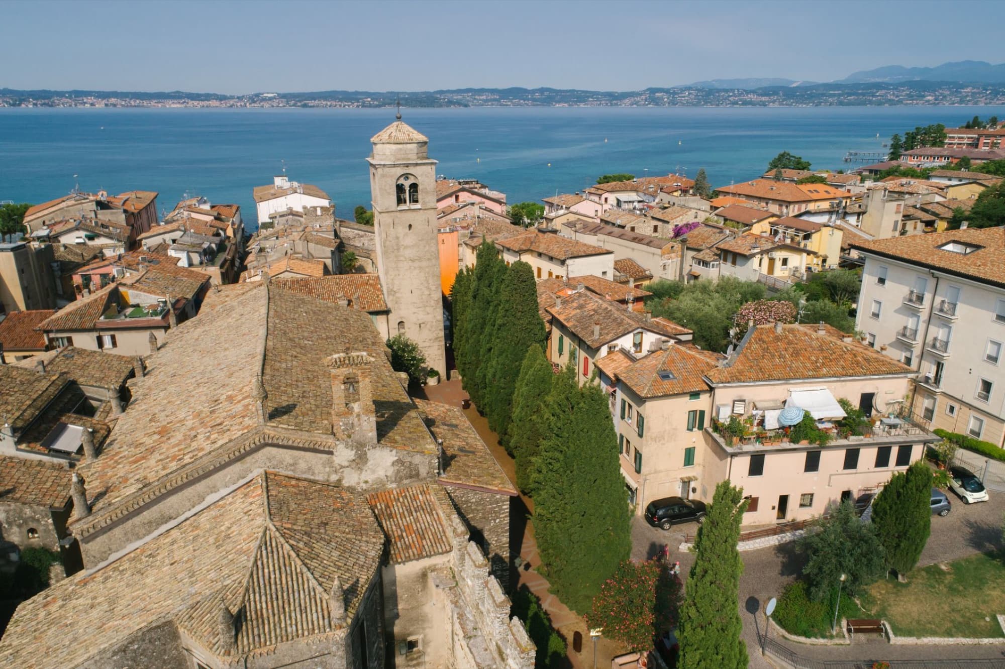 Stunning aerial shot of Sirmione town with Scaliger Castle and Lake Garda in Italy under clear skies.