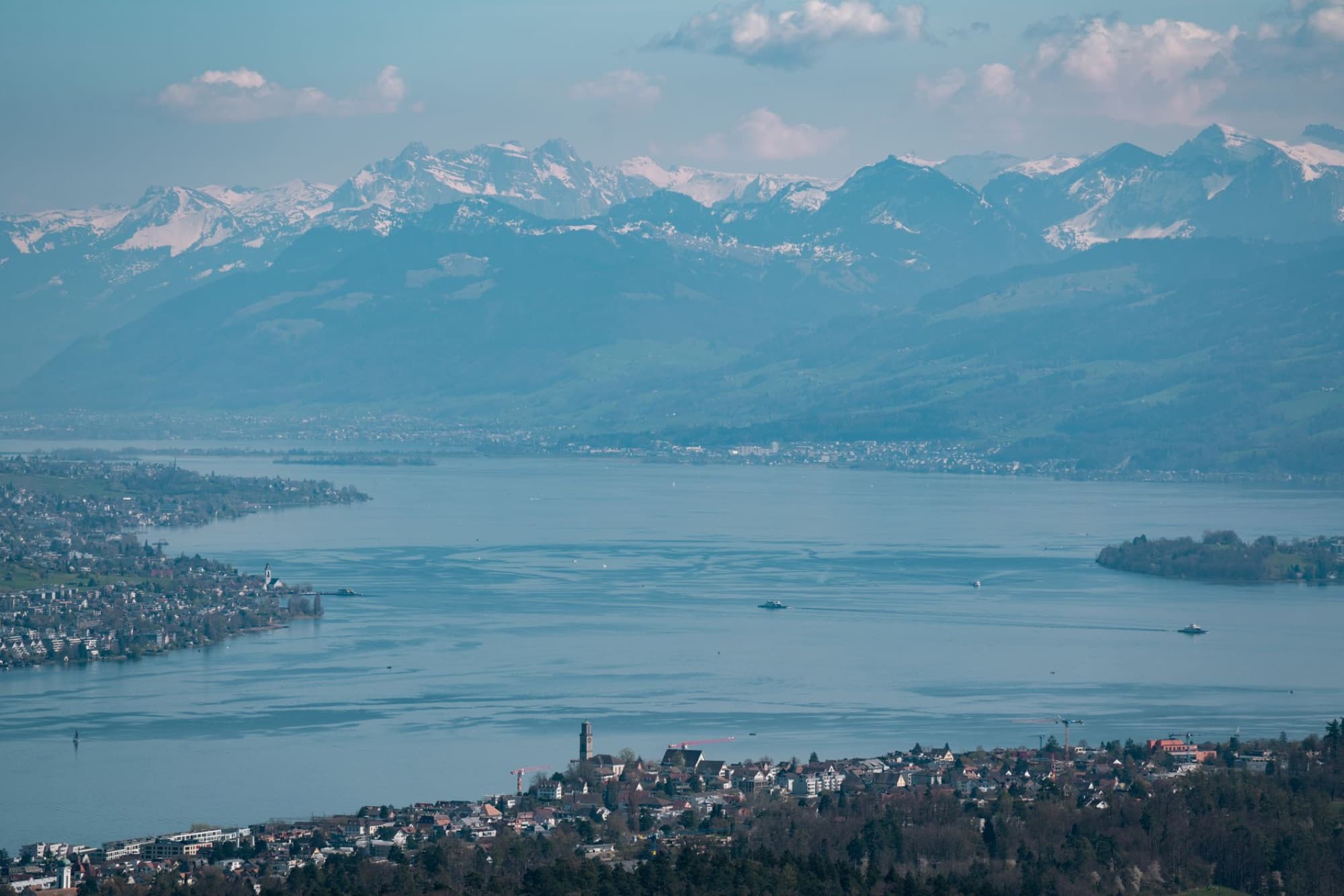 Scenic aerial view of Lake Zurich surrounded by the Swiss Alps, showcasing beautiful mountain landscapes and serene waters.