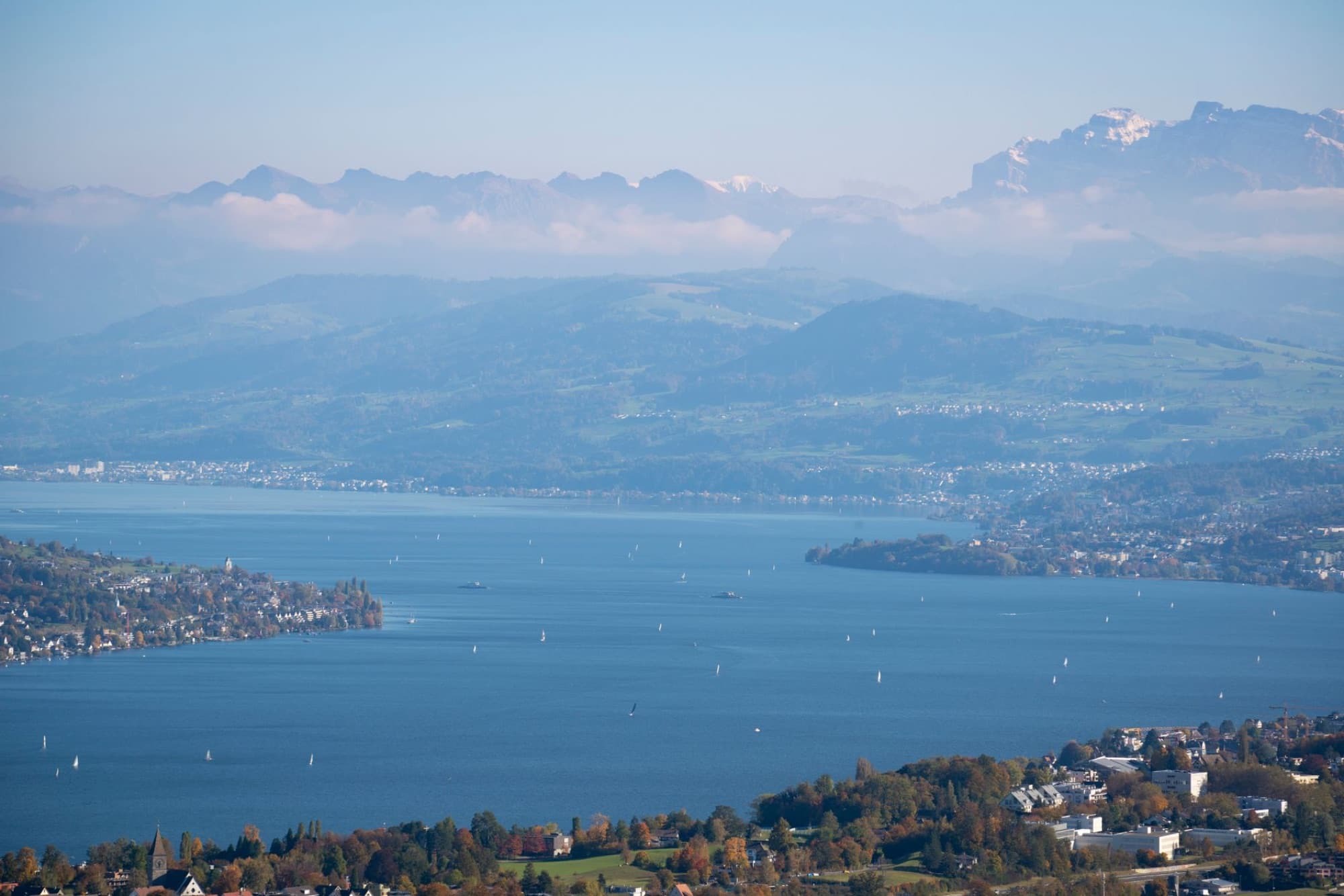 Picturesque aerial view of Lake Zurich surrounded by mountains and sailboats.