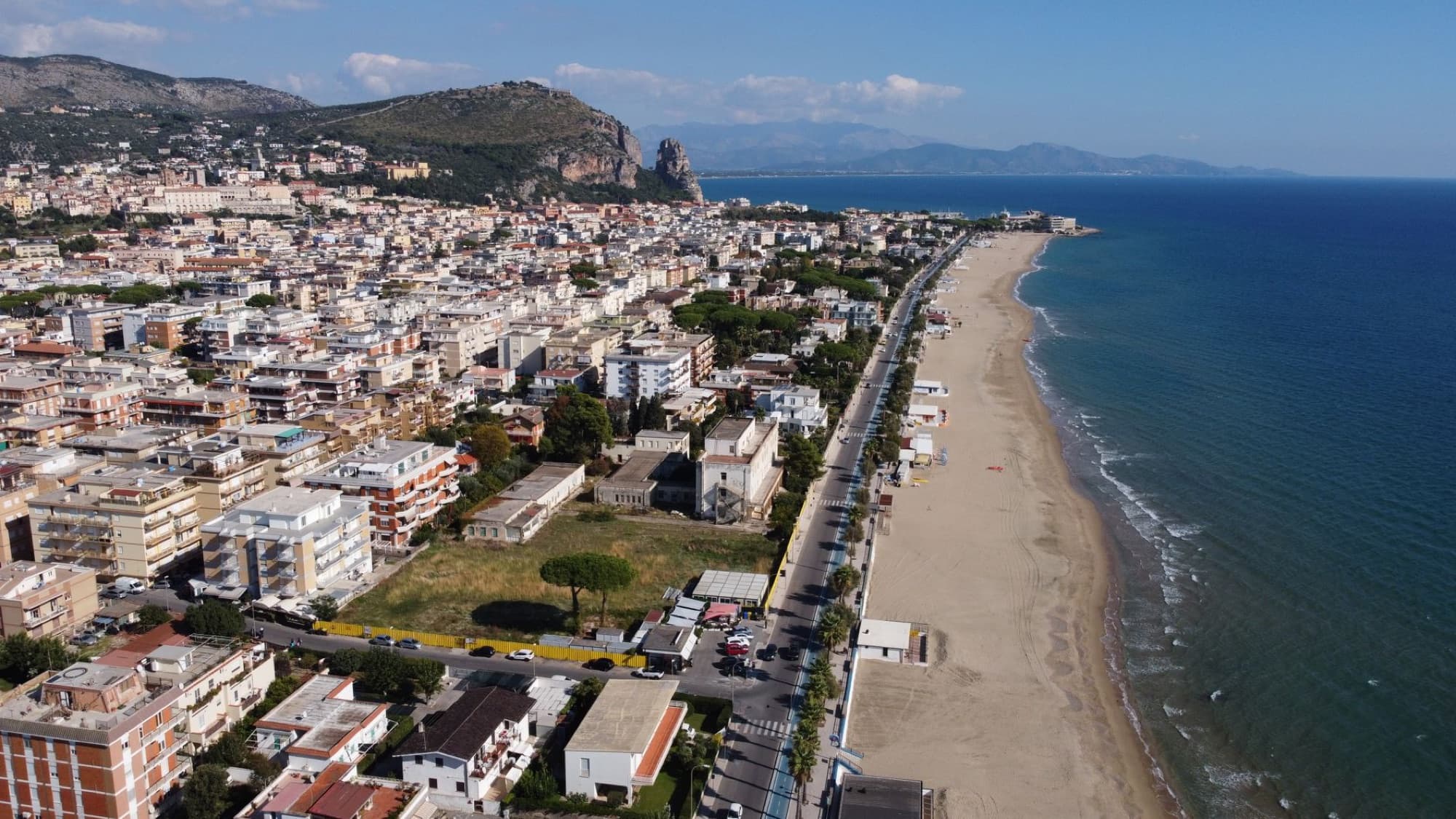 Aerial view of Latina city and beach in Lazio, Italy. Clear blue sky and coastline.