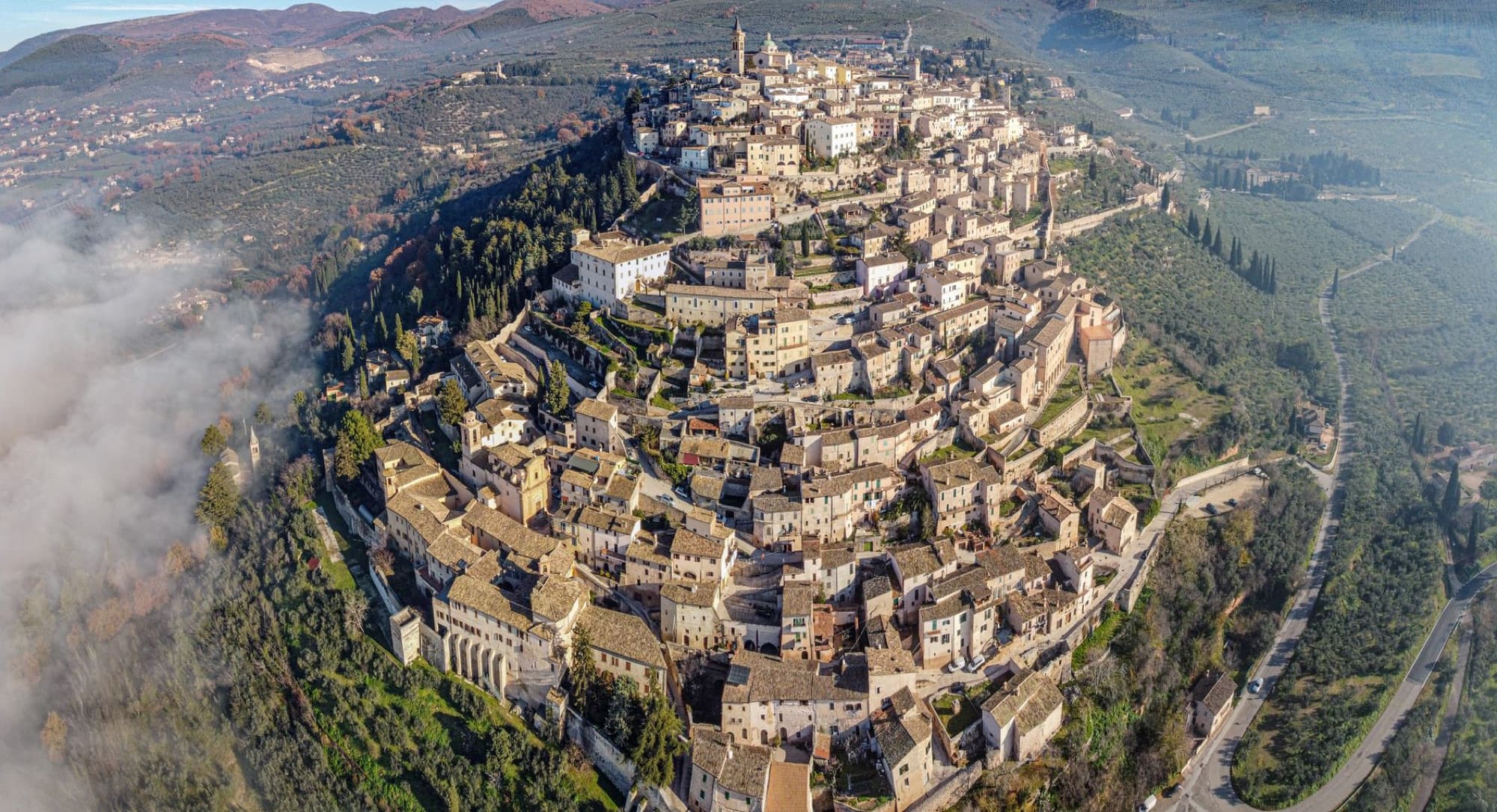 Drone view of medieval old San Marino city built on lush verdant hill in spacious valley