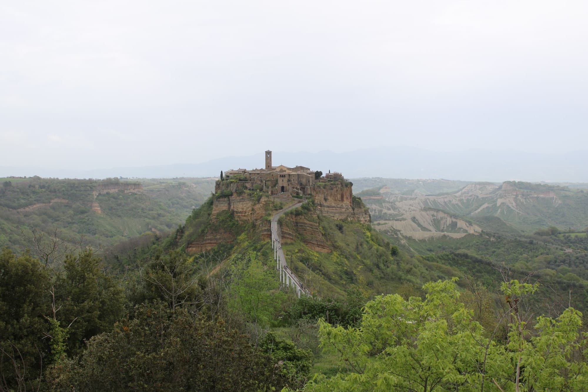 Explore Civita di Bagnoregio, an ancient hilltop village set against a scenic Italian landscape.