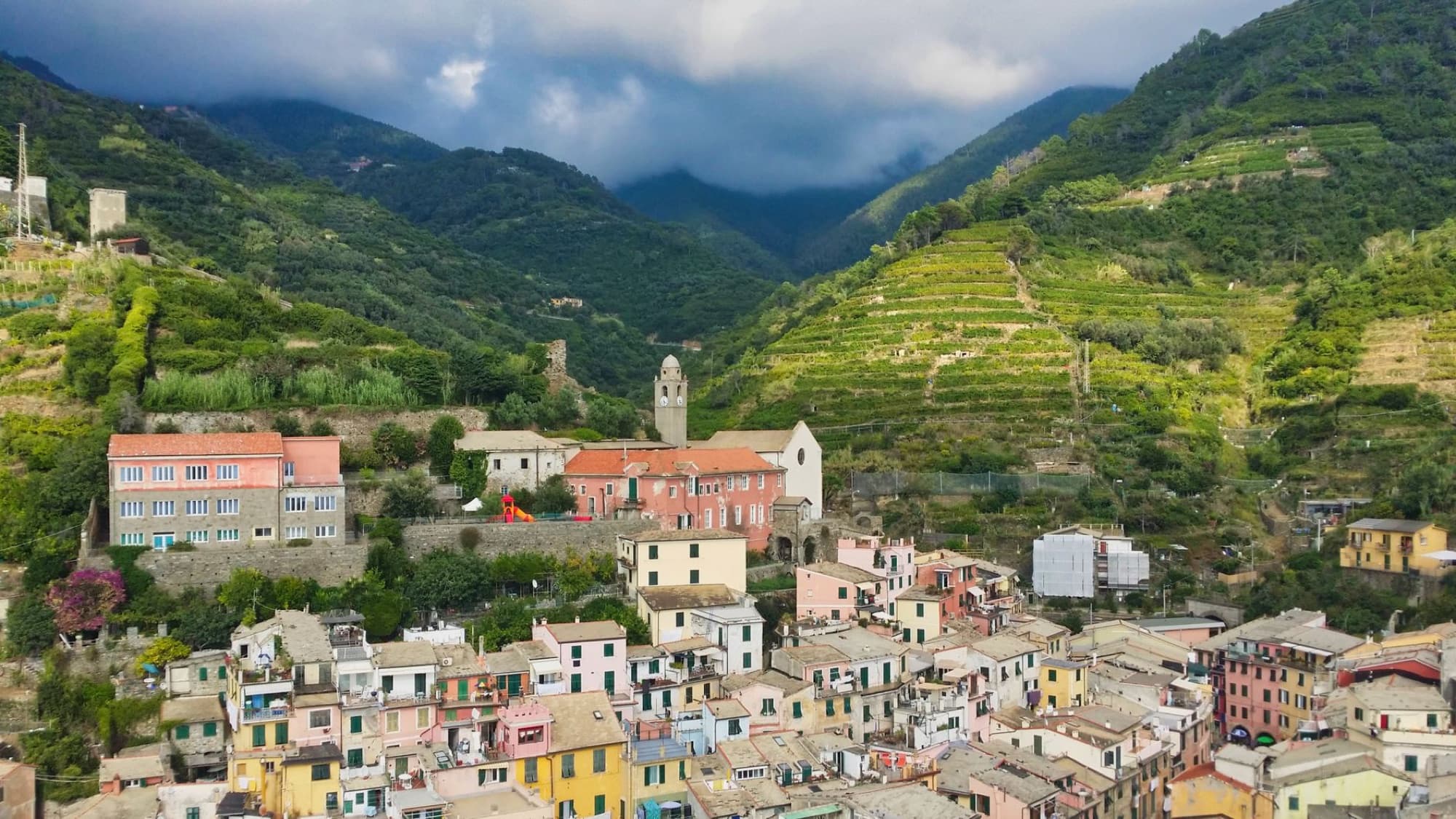 Aerial view of Vernazza village surrounded by lush hills in Liguria, Italy.