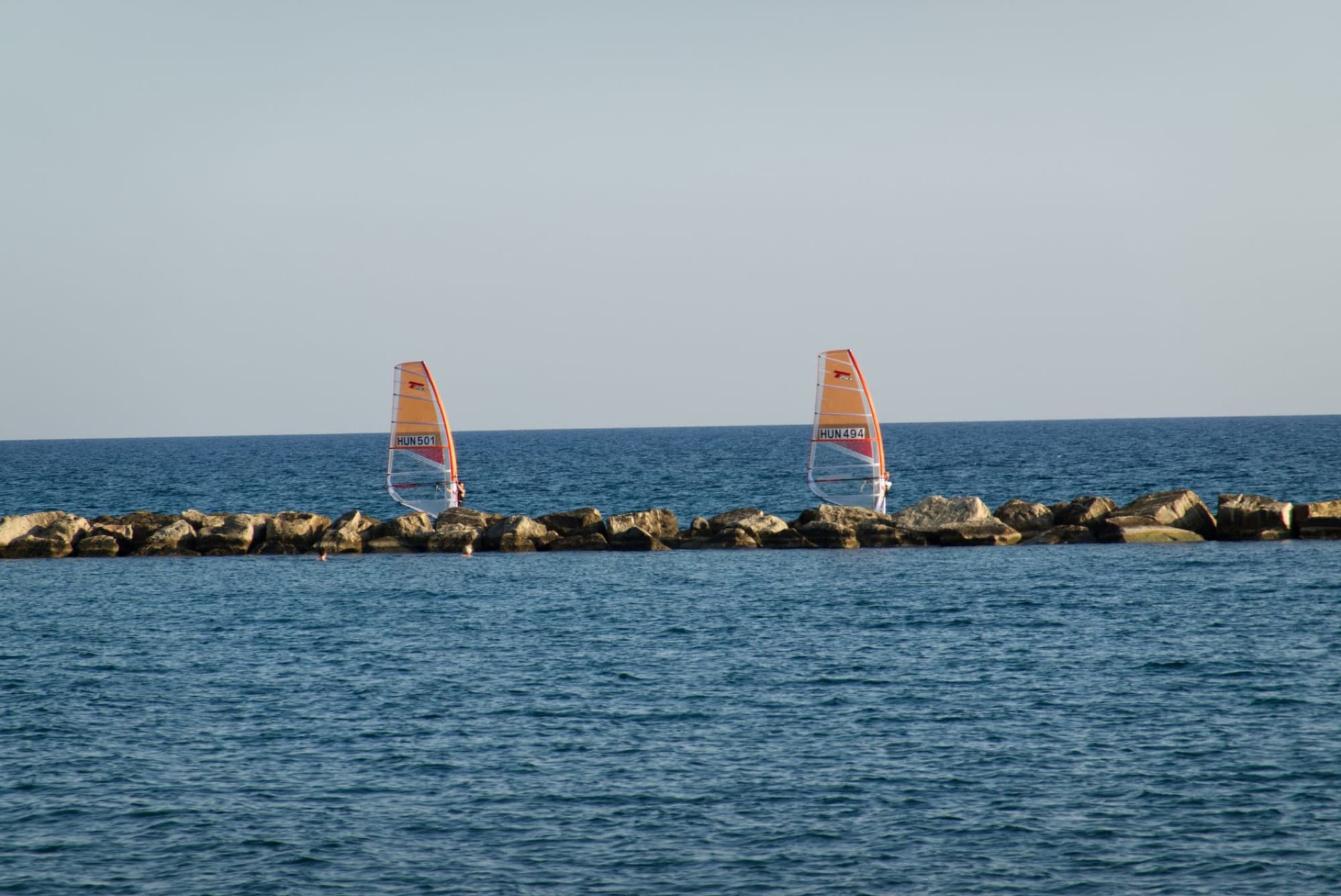 Exciting windsurfing experience on the rocky coast of Limassol, Cyprus.
