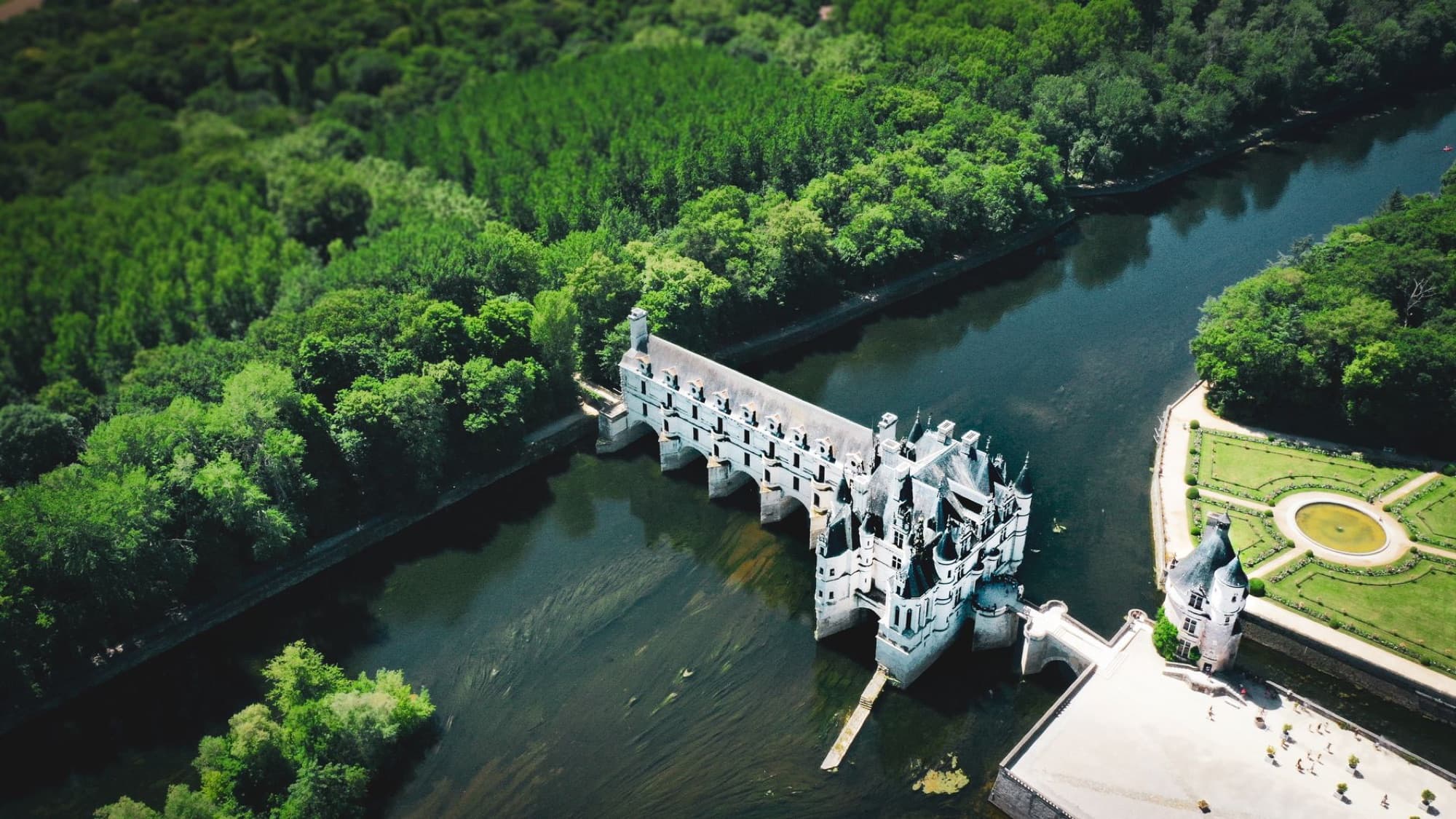 Stunning aerial view of Château de Chenonceau surrounded by lush greenery in Centre-Val de Loire, France.