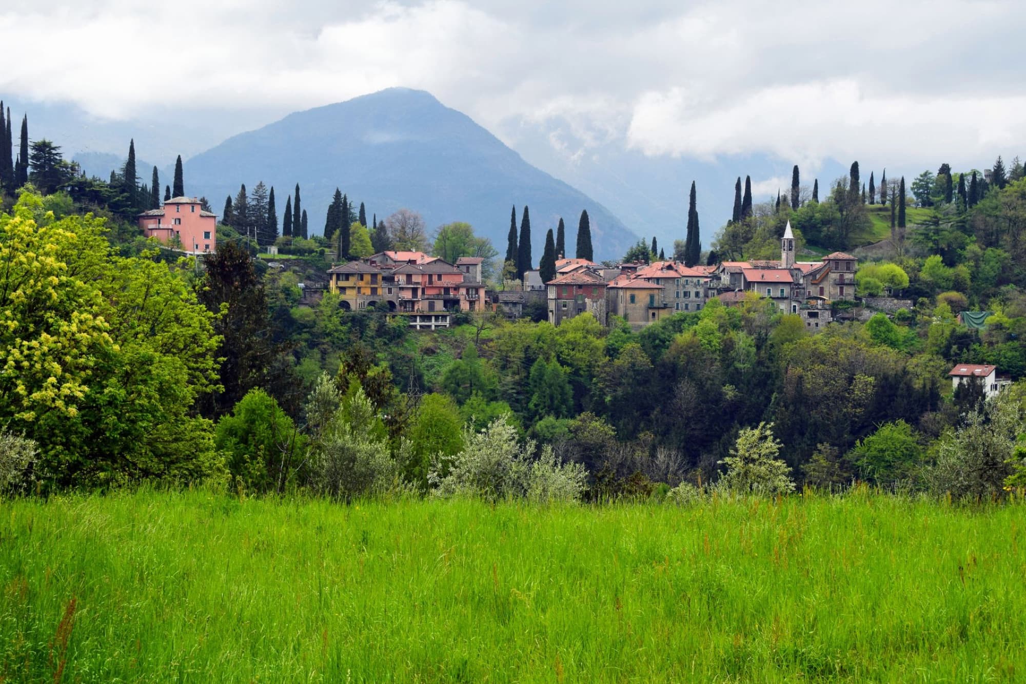 Picturesque landscape of Perledo village in Lombardy, Italy with lush greenery and mountain backdrop.