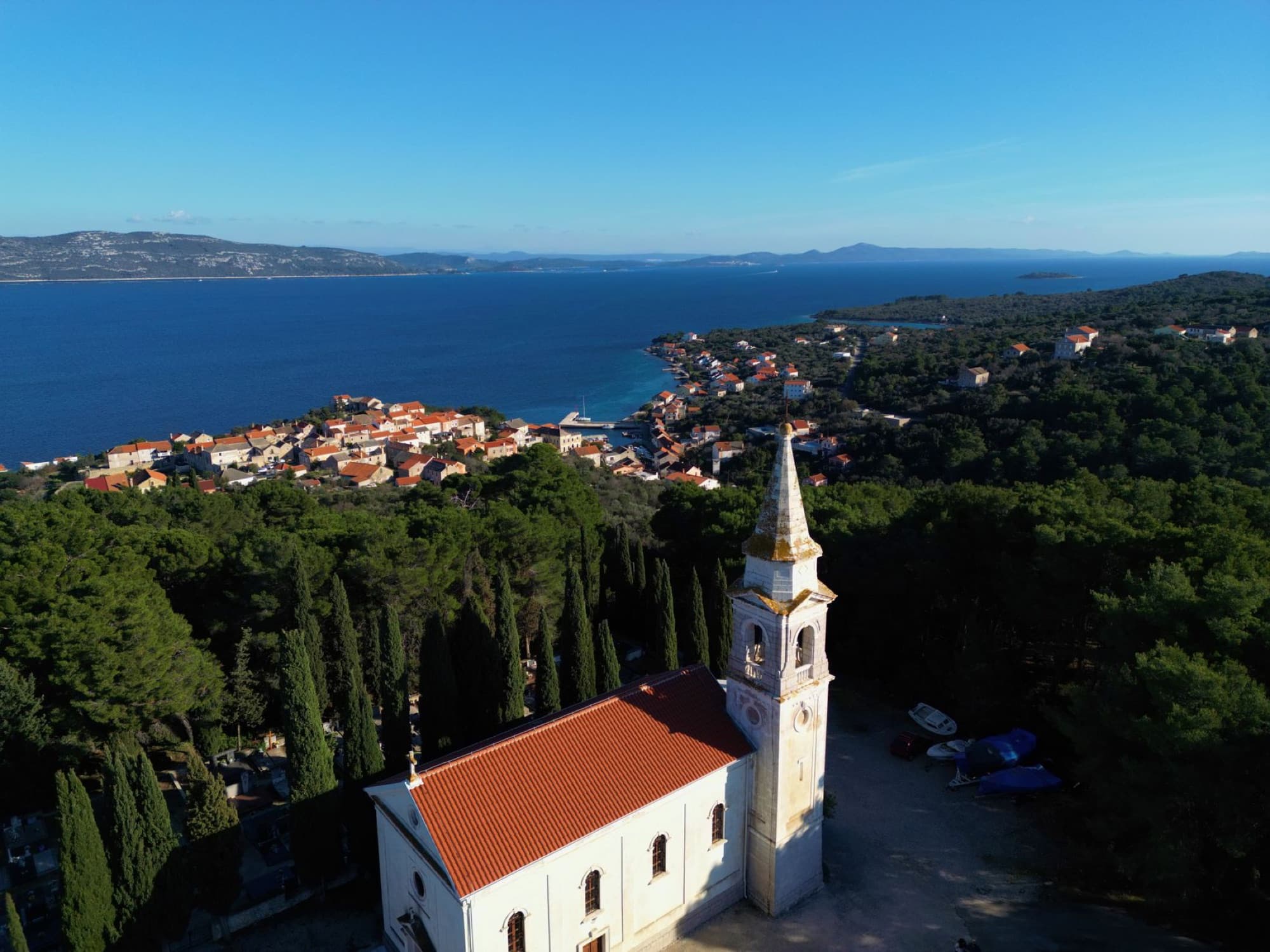 Aerial view of Veli Iž and its coastline in Croatia, showcasing a picturesque village and clear sea.
