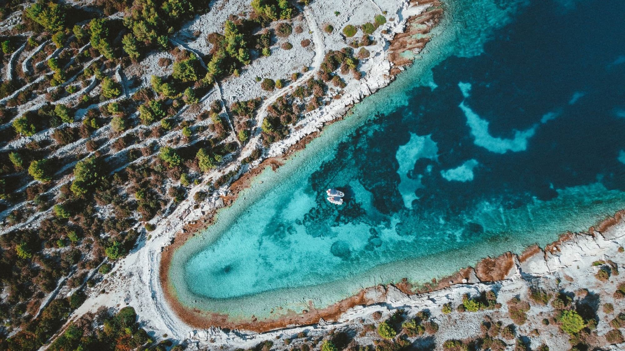 Aerial shot capturing Croatia's stunning turquoise coast and rocky shoreline.