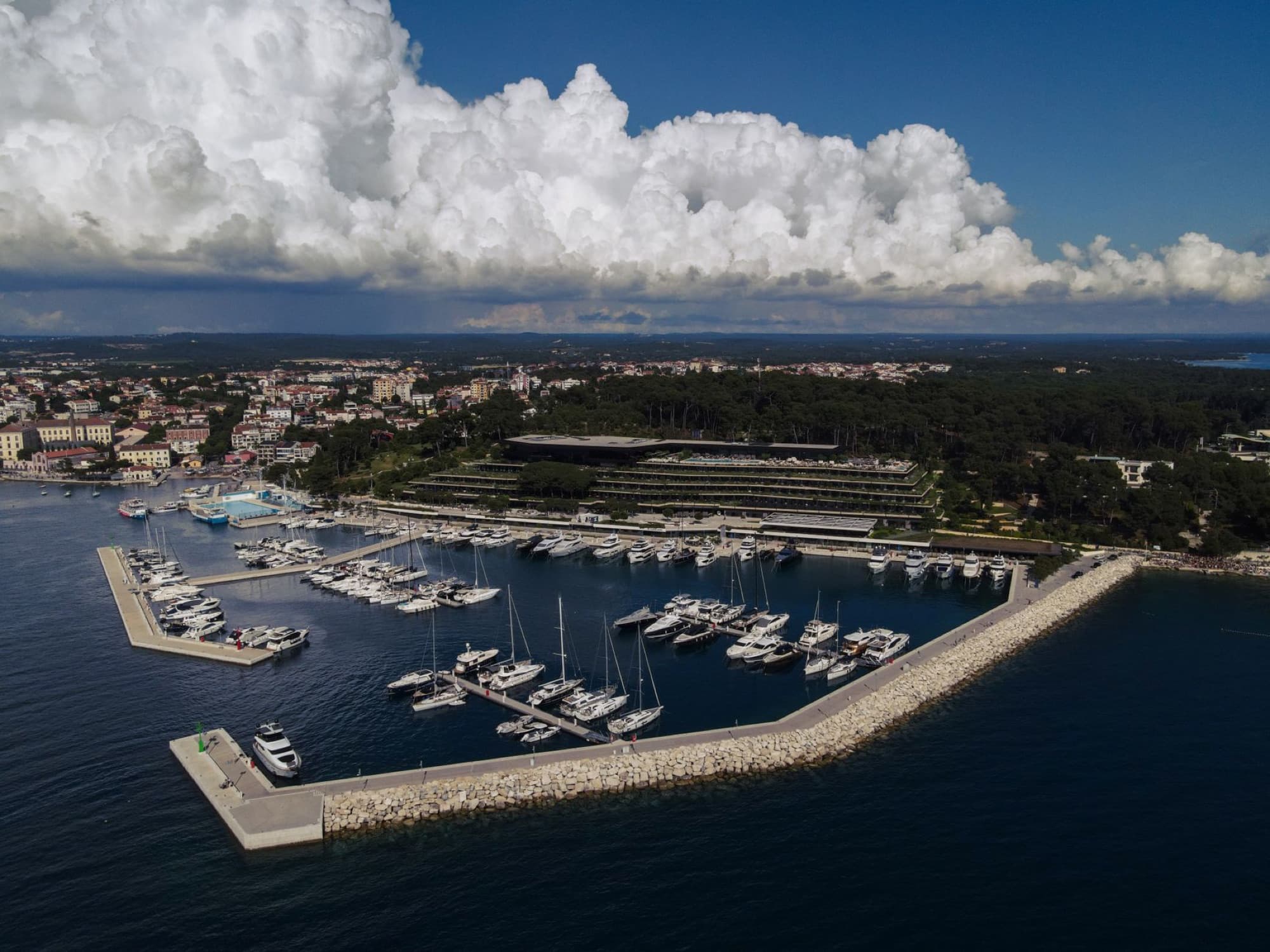 Stunning aerial view of Rovinj's marina in summer, showcasing yachts and coastal town charm.