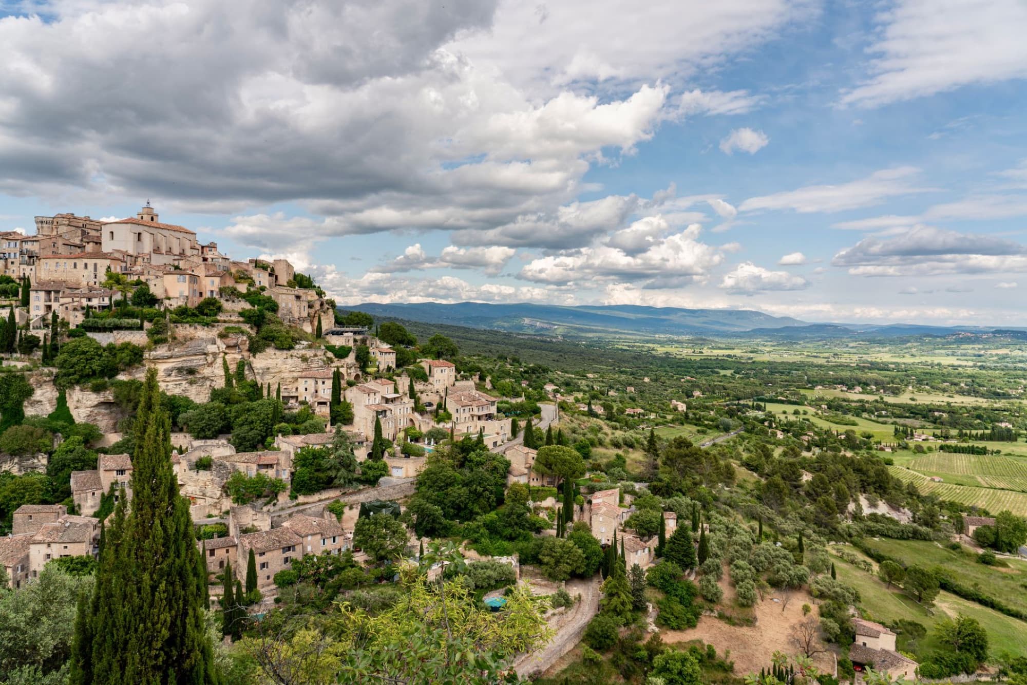 Scenic view of a Provence village with terraced houses and lush landscape.