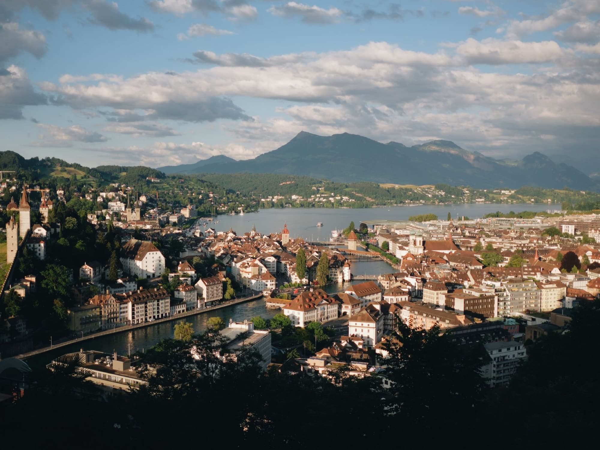 A picturesque aerial view of Lucerne, Switzerland featuring the cityscape, lake, and surrounding mountains.