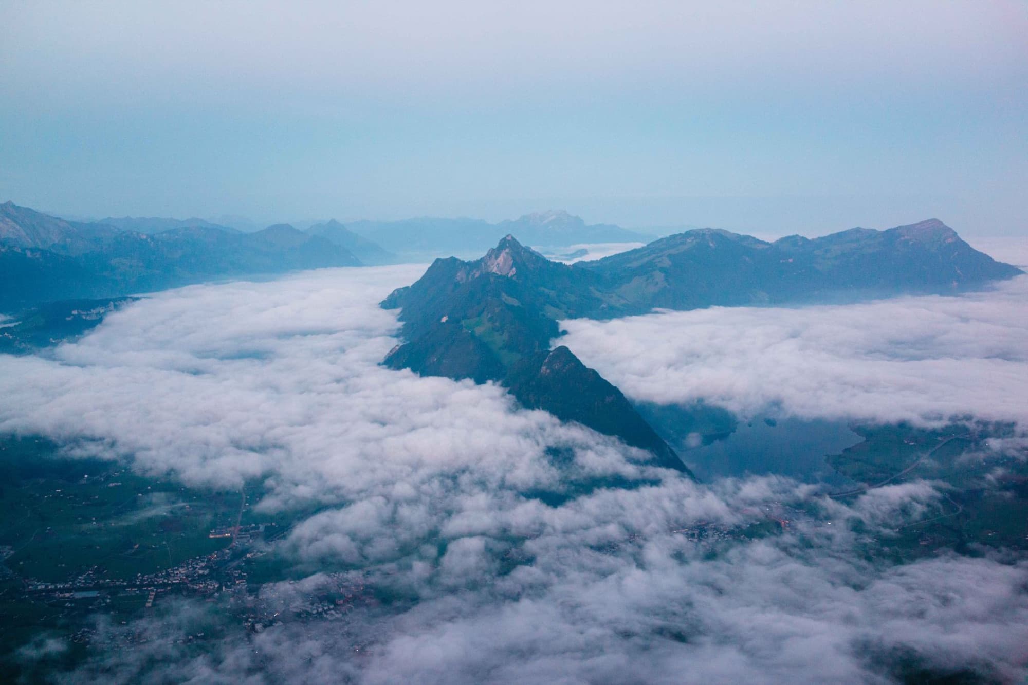 A mesmerizing aerial view of the Swiss Alps with clouds and mountains near Schwyz, Switzerland.