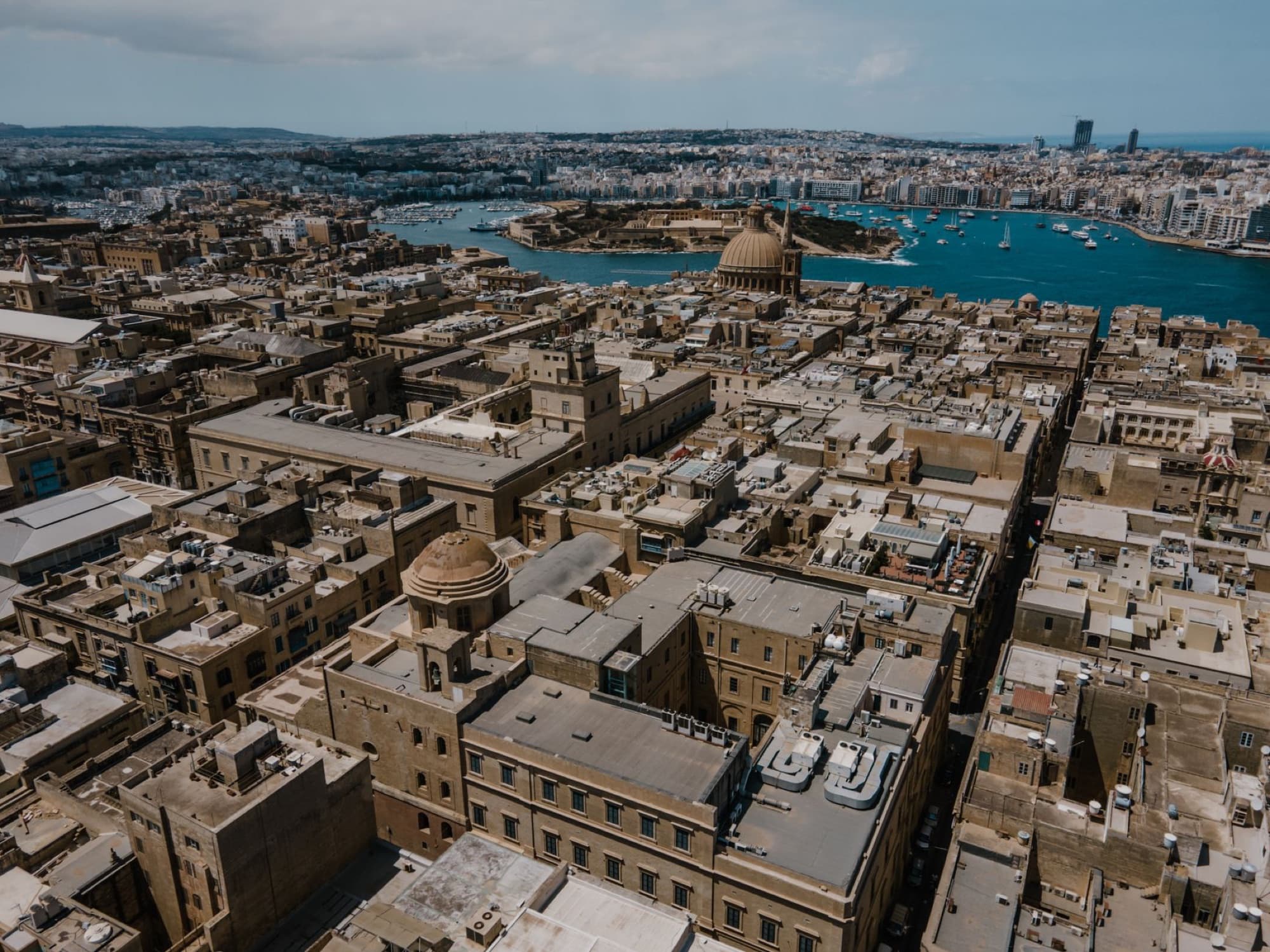 A stunning aerial shot of Il-Belt Valletta, Malta, showcasing its historic architecture and Mediterranean coastline.