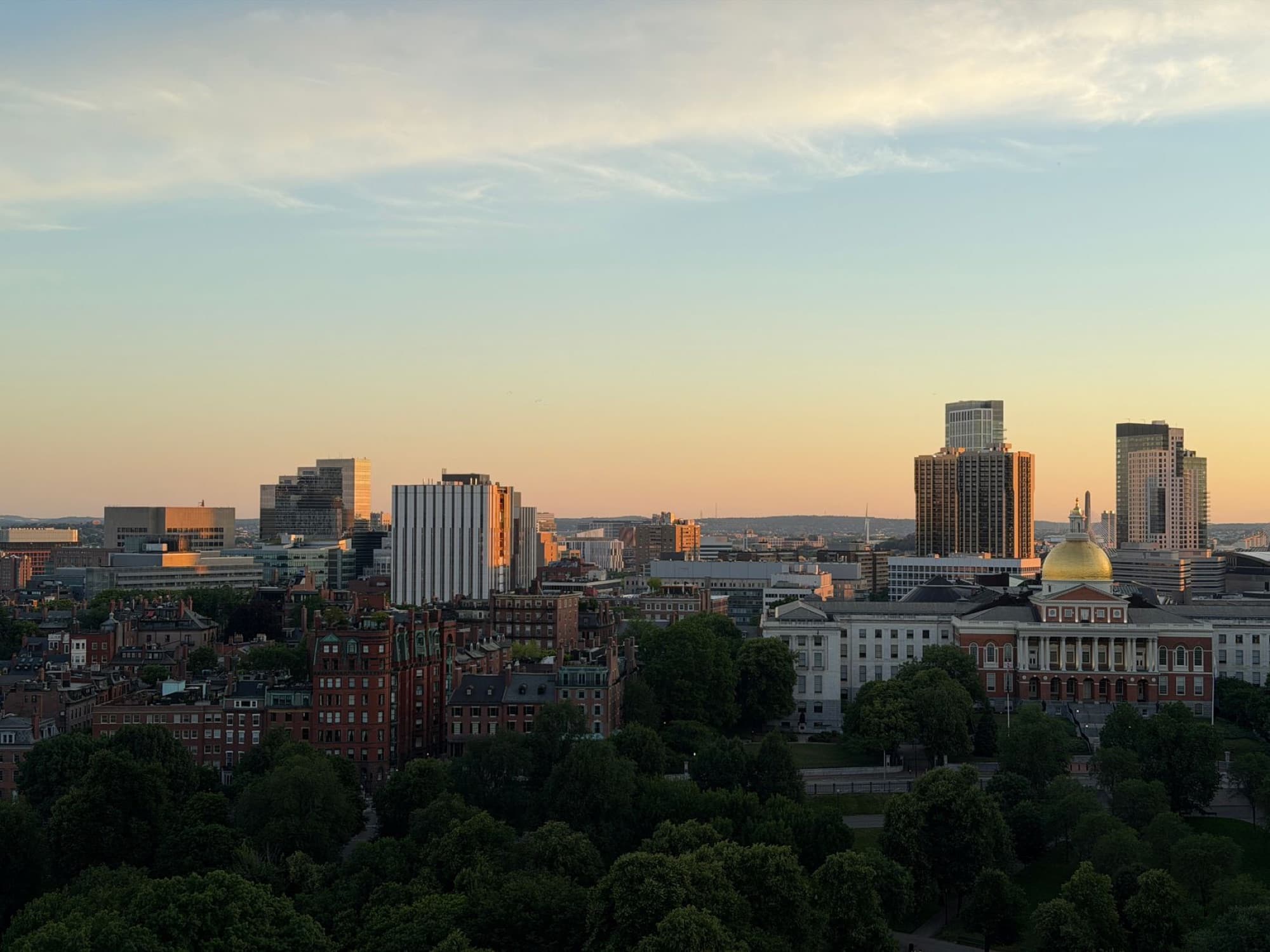 Aerial view of the Boston skyline during sunset, highlighting the Massachusetts State House in Boston, MA.