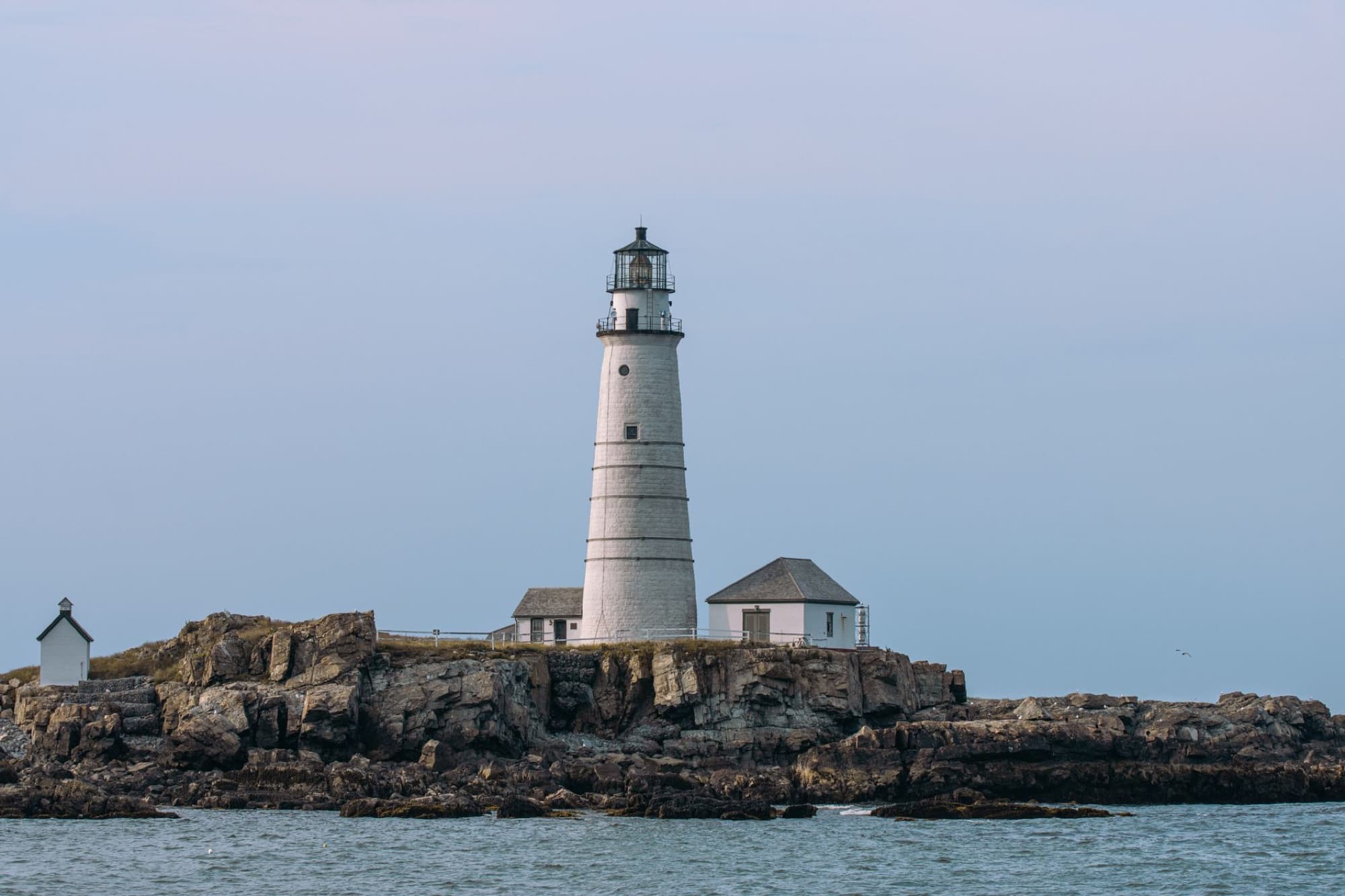 Scenic view of the iconic Boston Light Lighthouse on Little Brewster Island, a historic landmark in Massachusetts.
