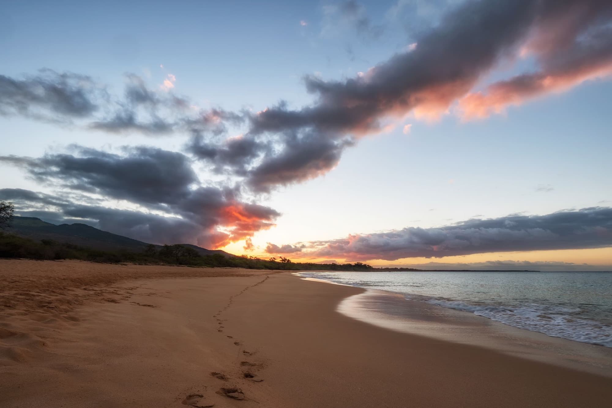 Capture of a breathtaking sunset over Makena Beach, Maui with vibrant skies and smooth ocean waves.