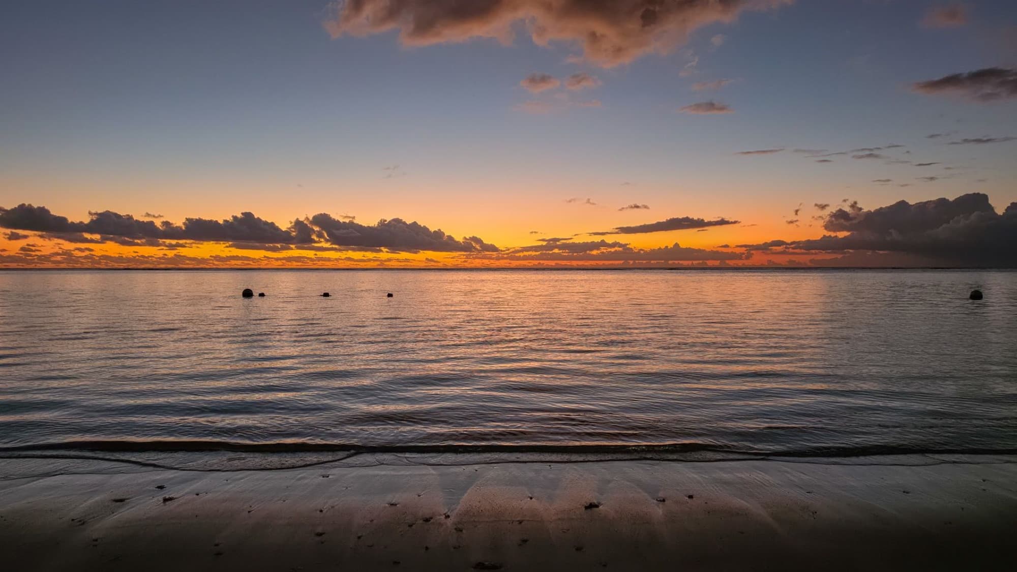 A breathtaking sunset view over the serene waters and sandy beach of Mauritius' Moka District.