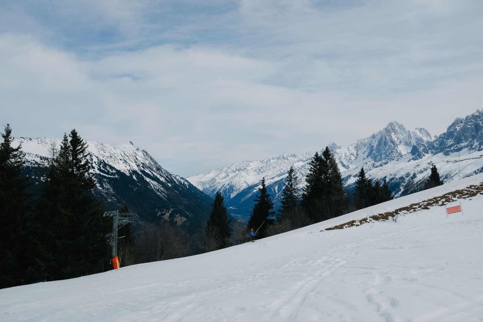 Scenic view of snow-covered mountains and pine trees in a winter alpine landscape, perfect for skiing.