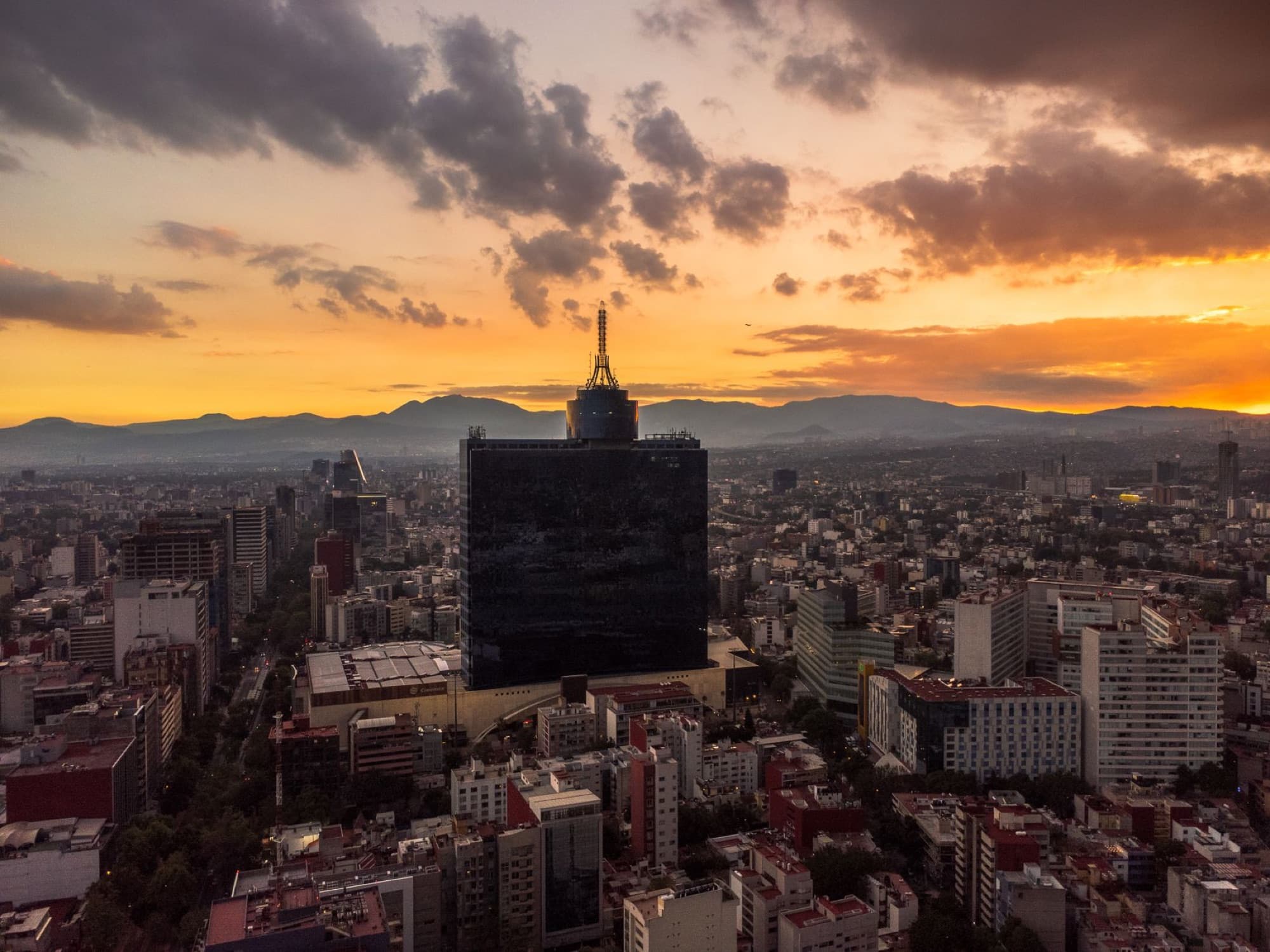 A breathtaking aerial view of Mexico City's skyline with vibrant sunset colors.