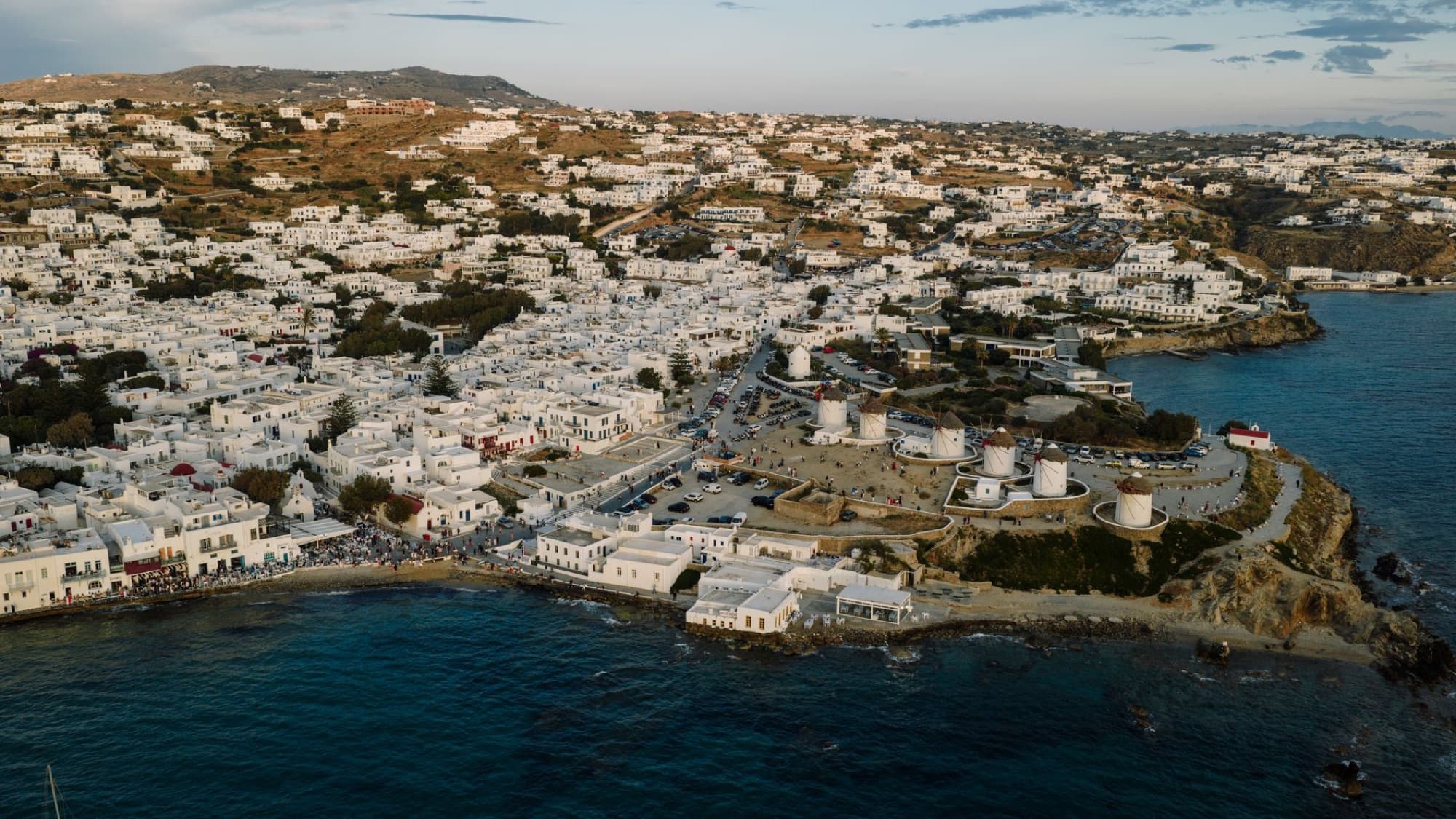 Stunning aerial shot of Mykonos town with its famous white buildings and windmills during daytime in Greece.
