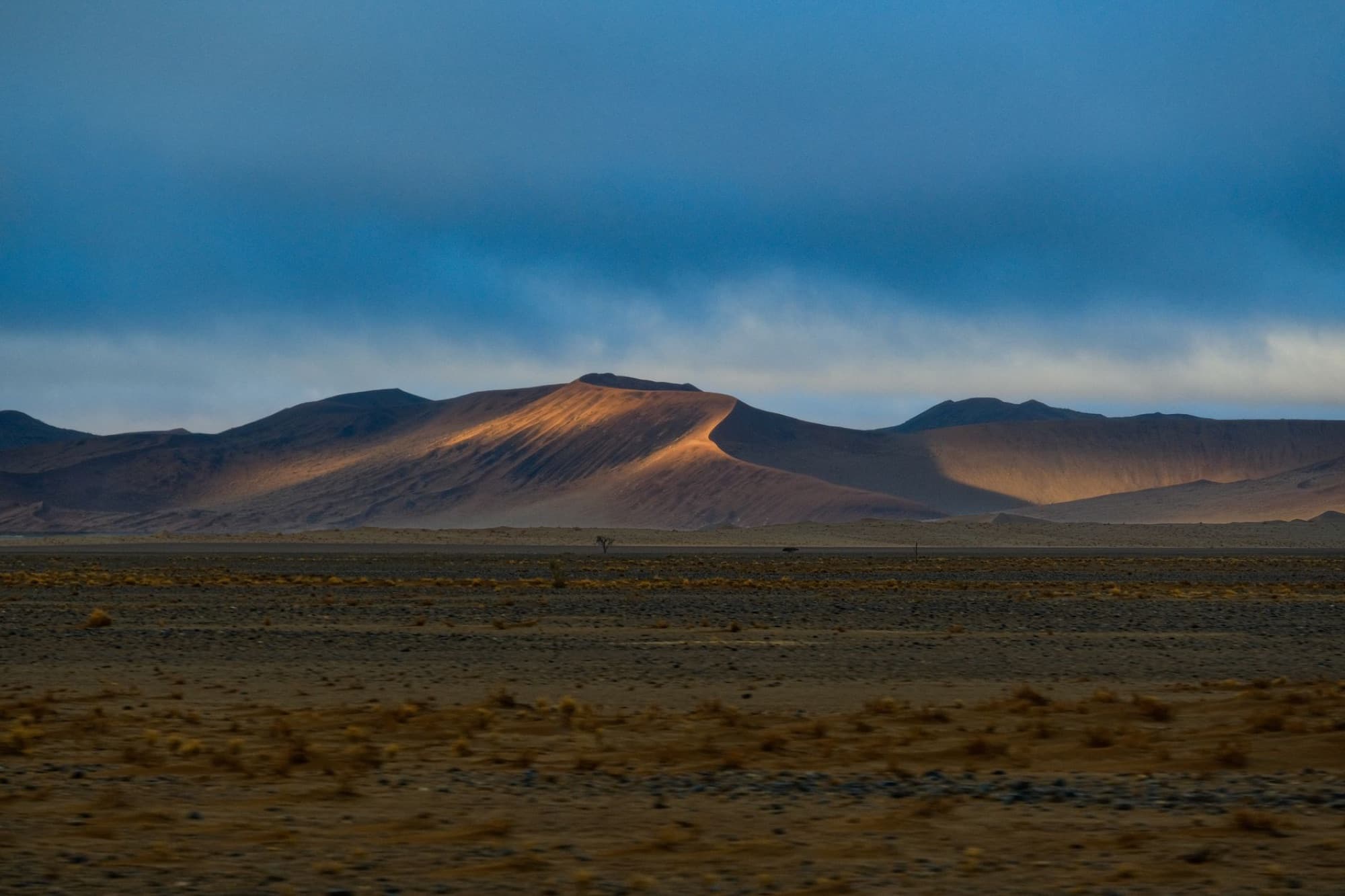 Captivating sunset light on desert mountains in Hardap, Namibia's vast wilderness.