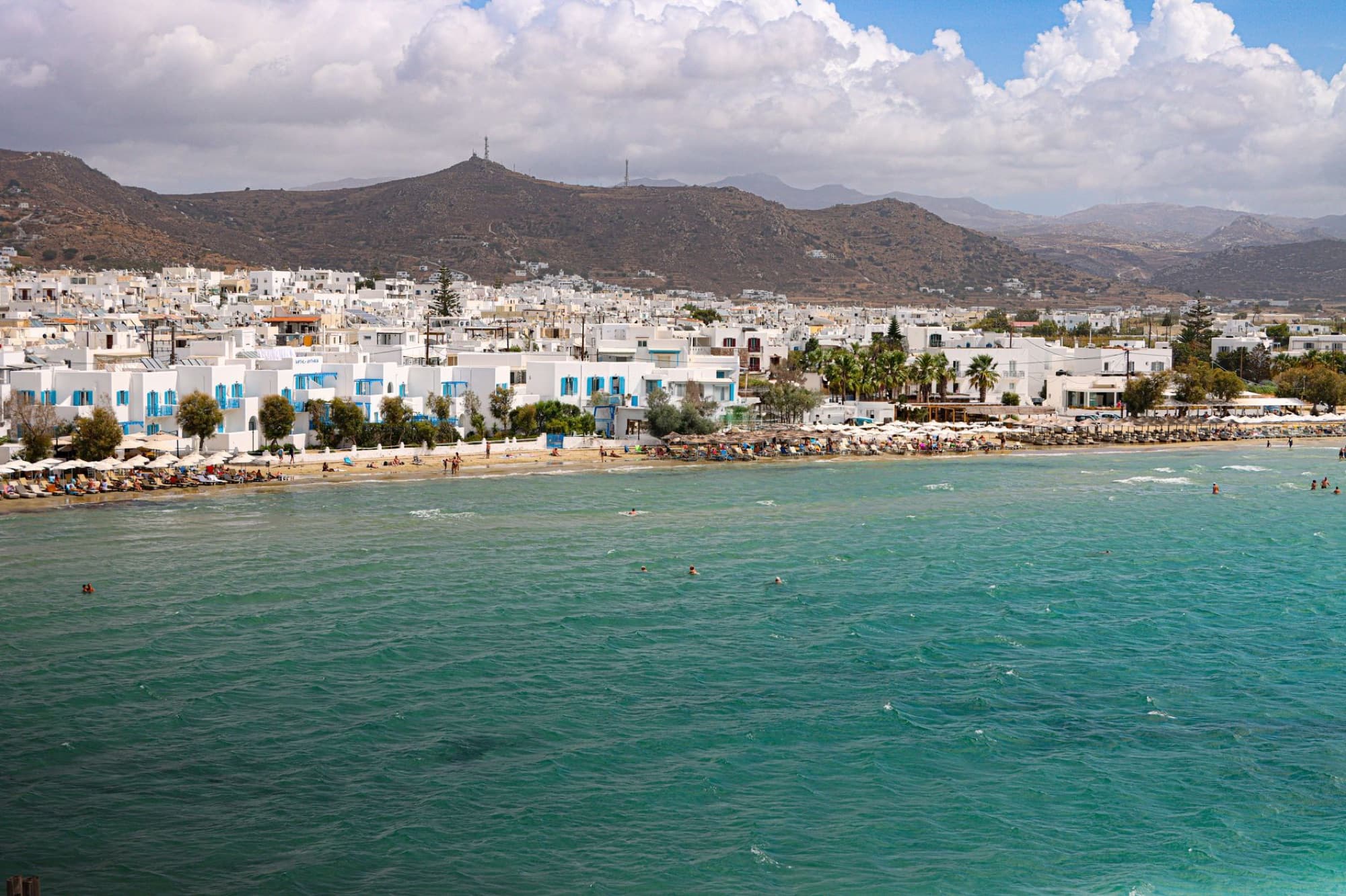 Stunning aerial view of Naxos beach with turquoise waters and white buildings.